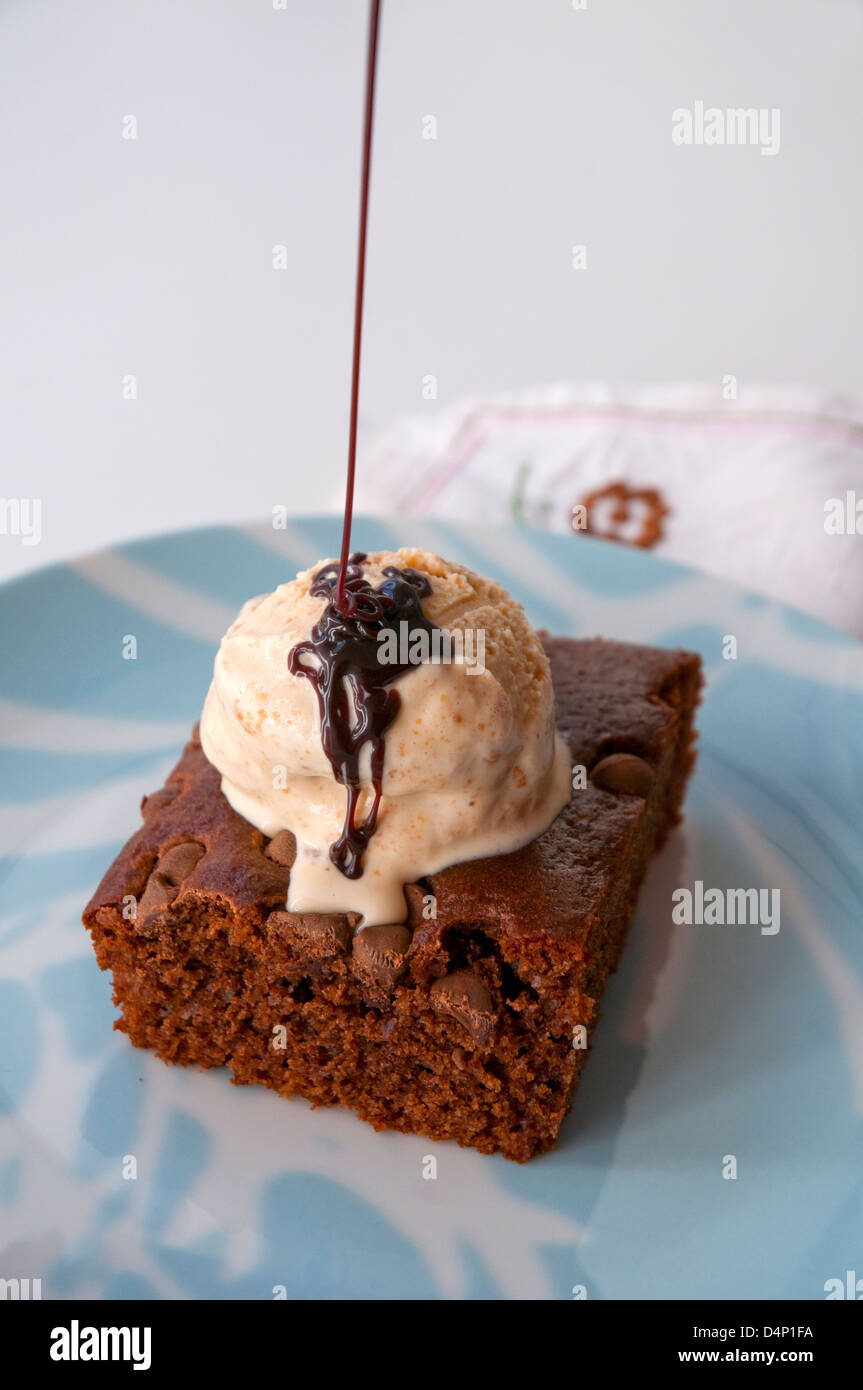 Chocolate cake with vanilla ice cream and chocolate syrup. Close view. Stock Photo