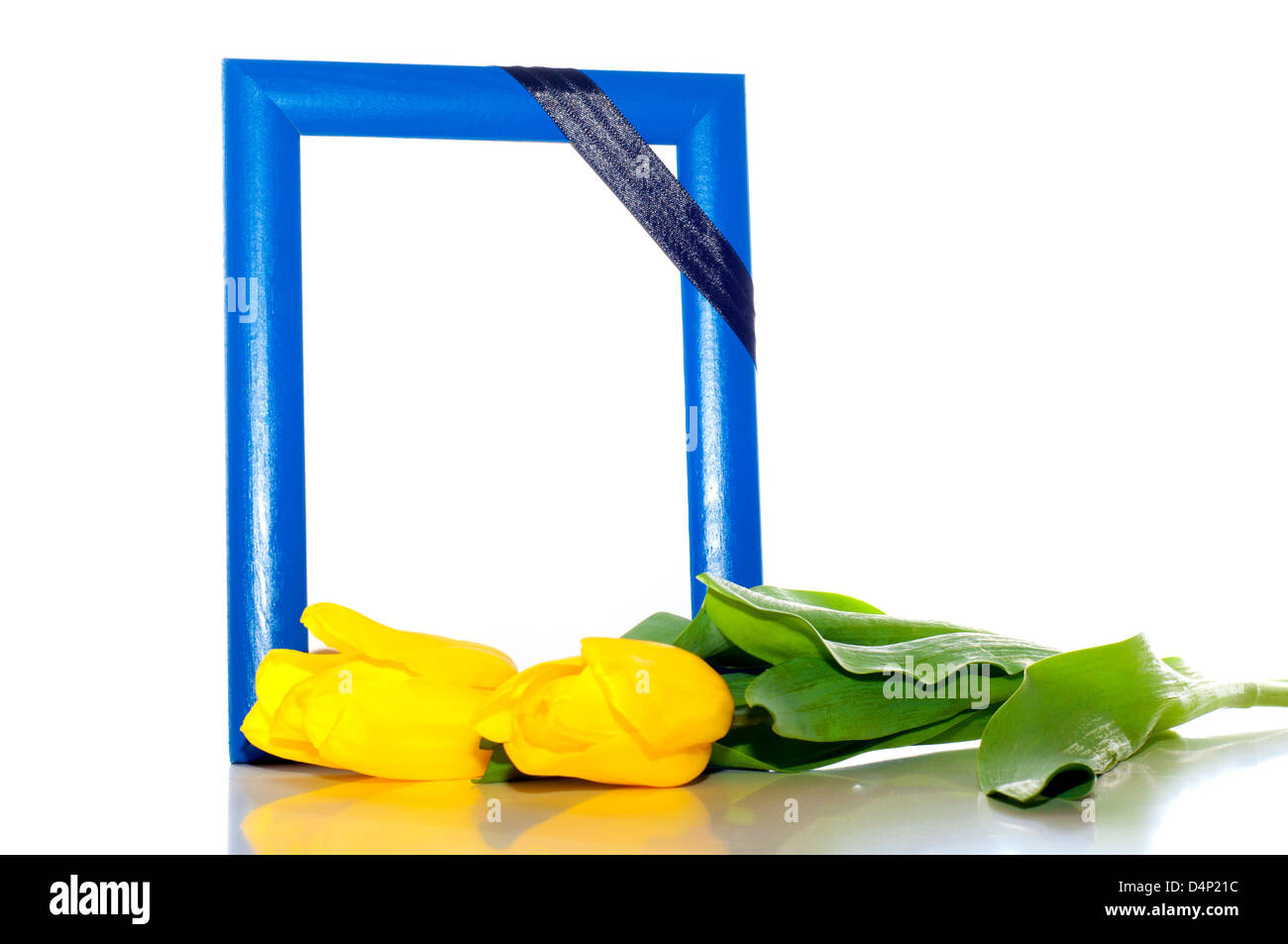 frame for the photo with a mourning black tape and two yellow tulips nearby Stock Photo