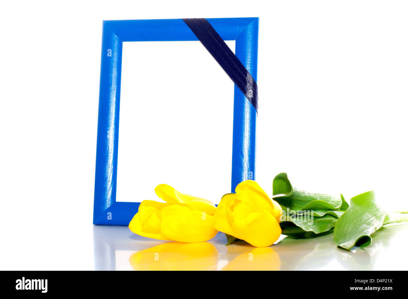 frame for the photo with a mourning black tape and two yellow tulips nearby Stock Photo