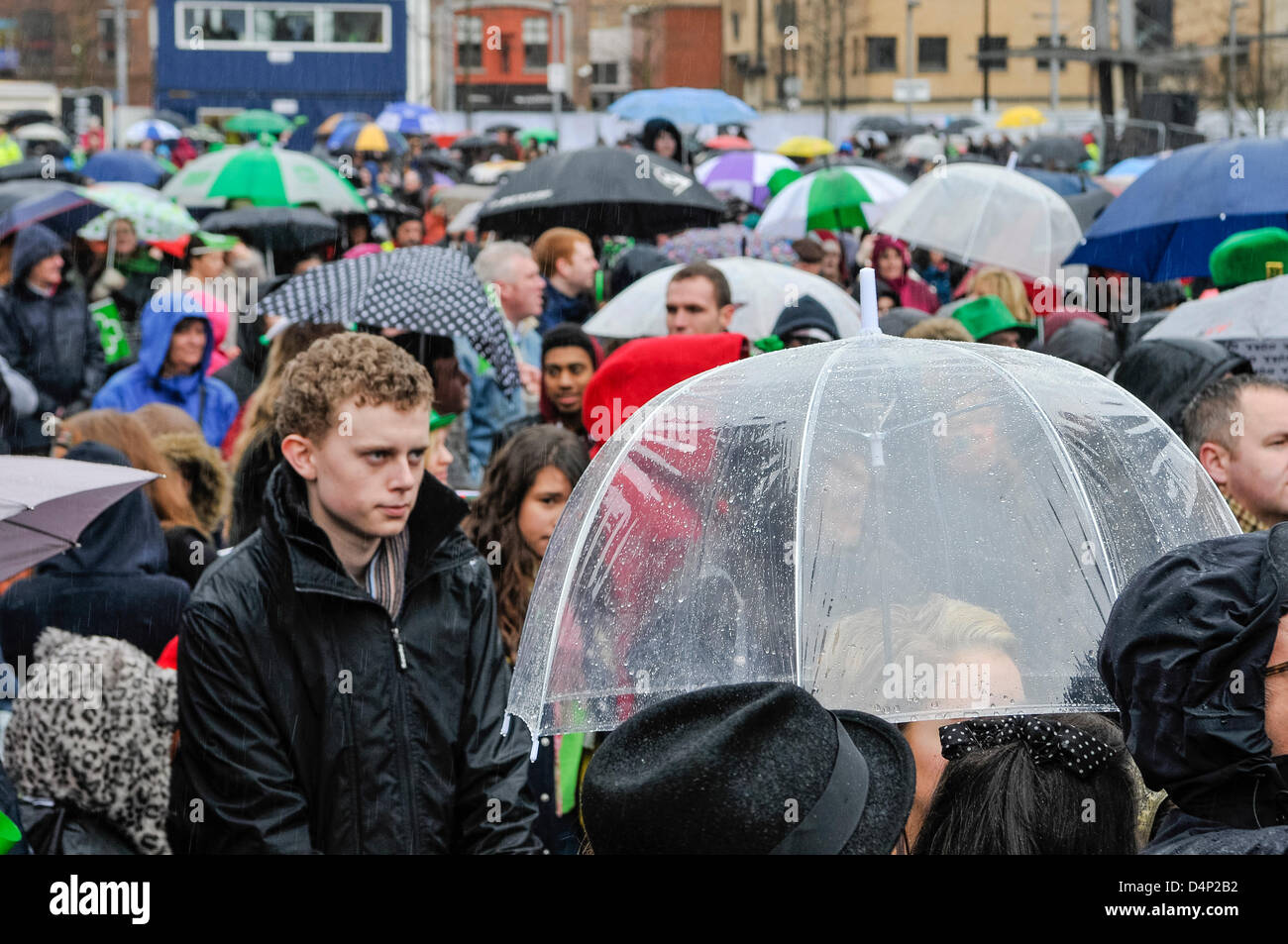 Audience members at an outdoor concert in heavy rain use umbrellas. Stock Photo