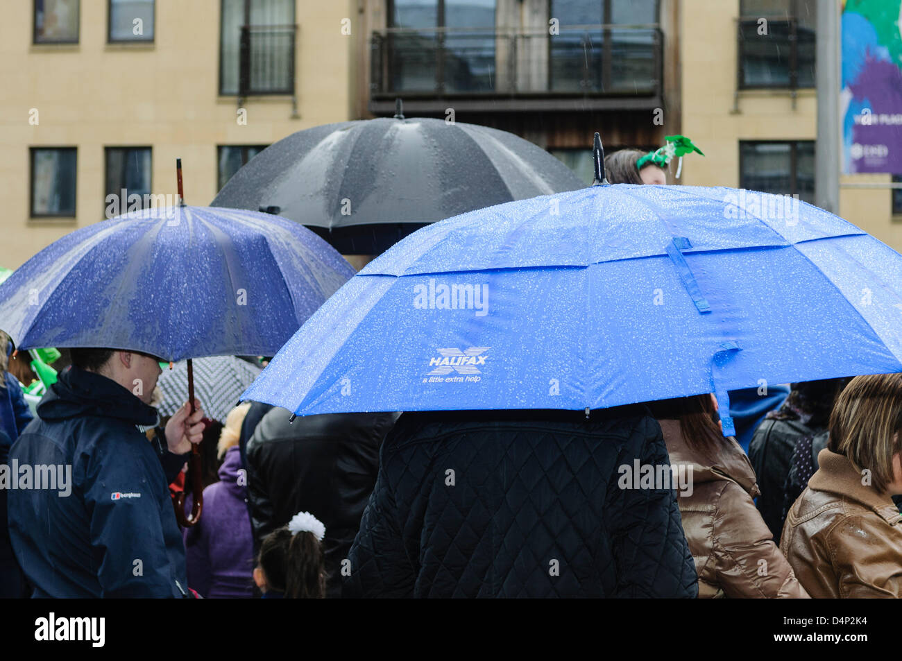 People sheltering under umbrellas in heavy rain Stock Photo