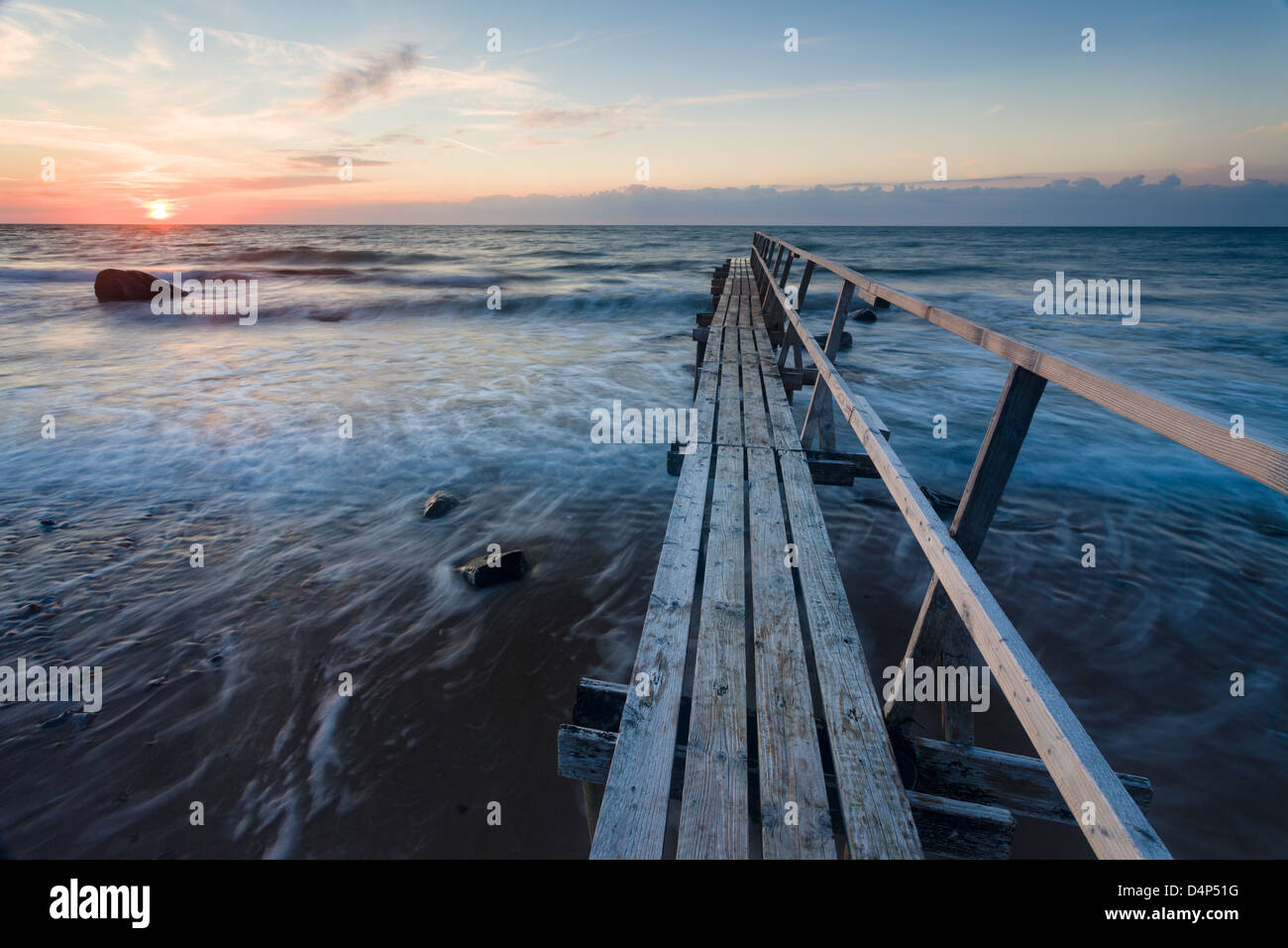 A badebro, or wooden bathing jetty, at sunset at Smidstrup Strand, on the north coast of the island of Zealand in Denmark. Stock Photo