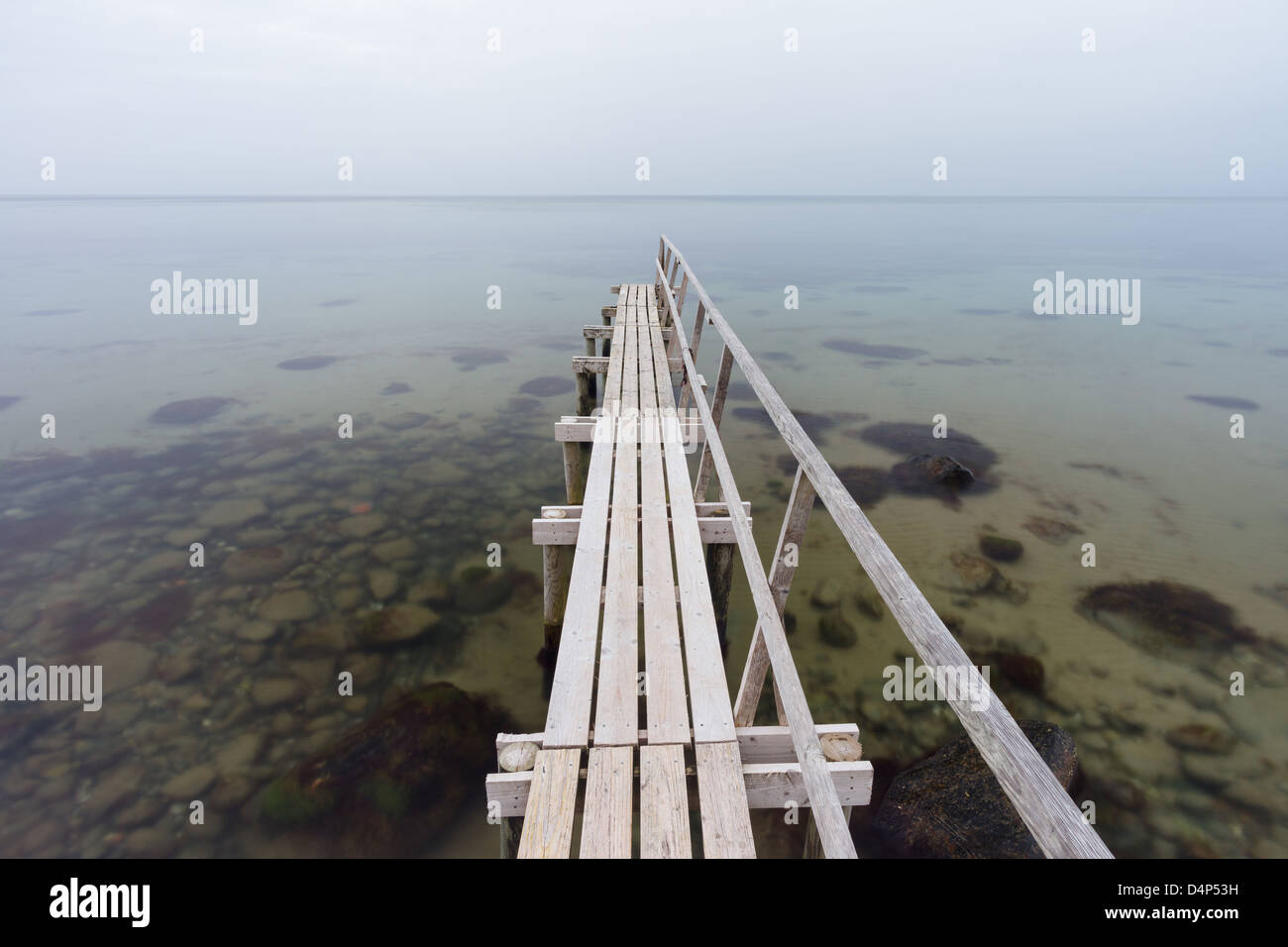 A badebro, or wooden bathing jetty, at sunset at Smidstrup Strand, on the north coast of the island of Zealand in Denmark. Stock Photo