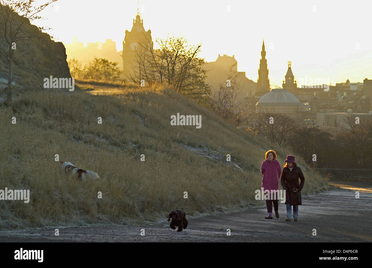 two women dog walkers on calton hill at sunrise on frosty day Stock Photo