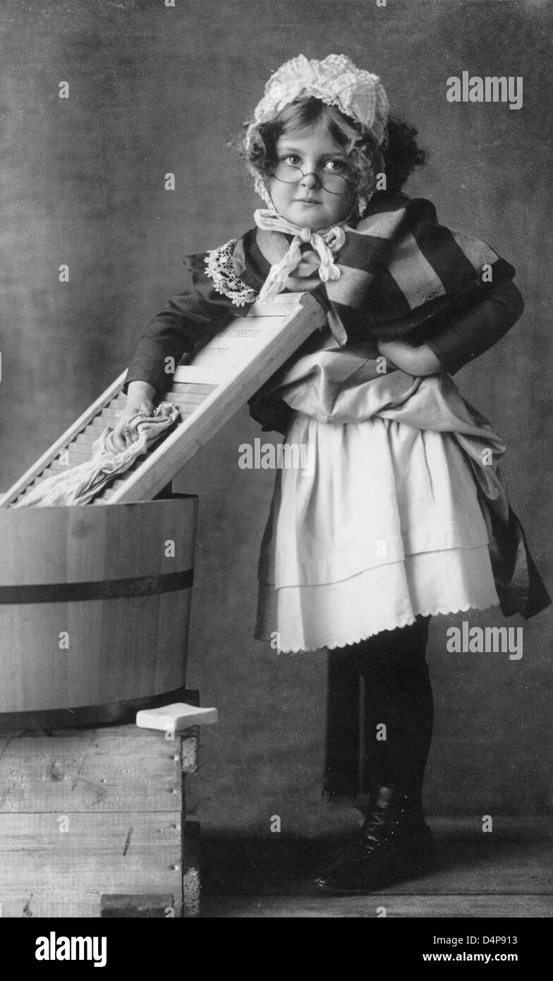 Girl wearing eyeglasses, bonnet and apron, with washboard and tub 1898 Stock Photo