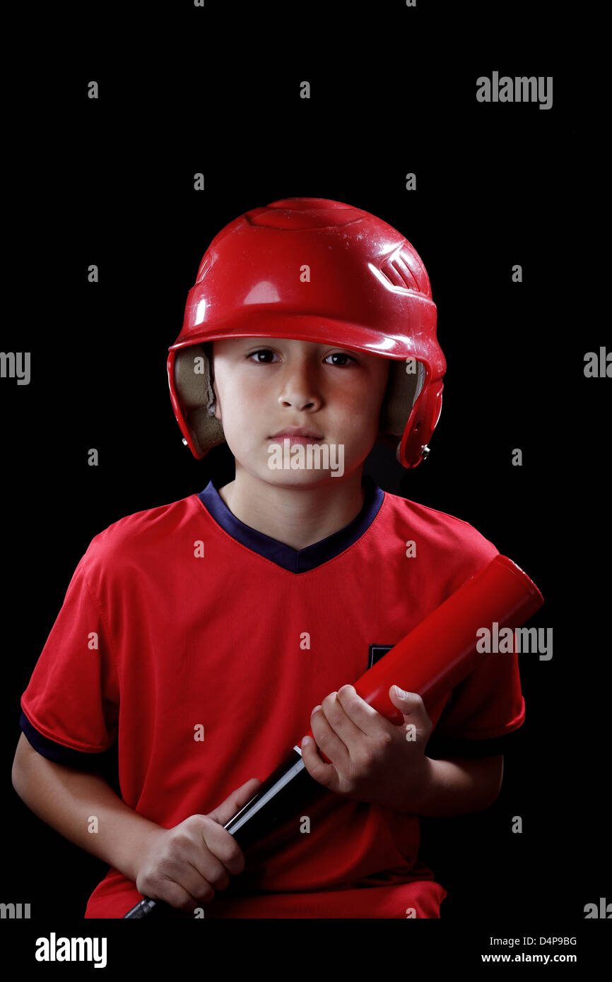 Young serious boy with red baseball helmet on black background - dramatic lighting style Stock Photo