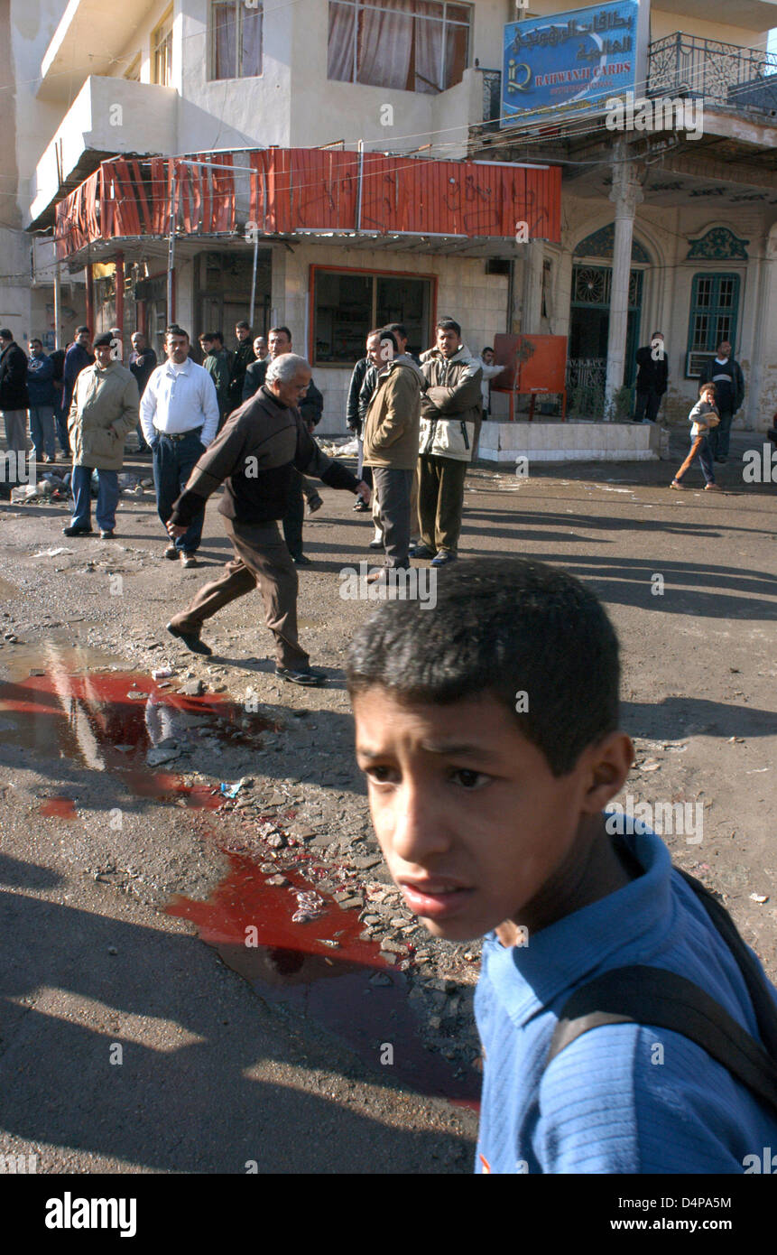 Attack against the U.S. occupation troops in the Baghdad neighborhood of Kerrada, causing serious damage to the local population. The attack killed an Iraqi and another merchant, 37, was injured. People passing by, including children, watching a big bloodb Stock Photo