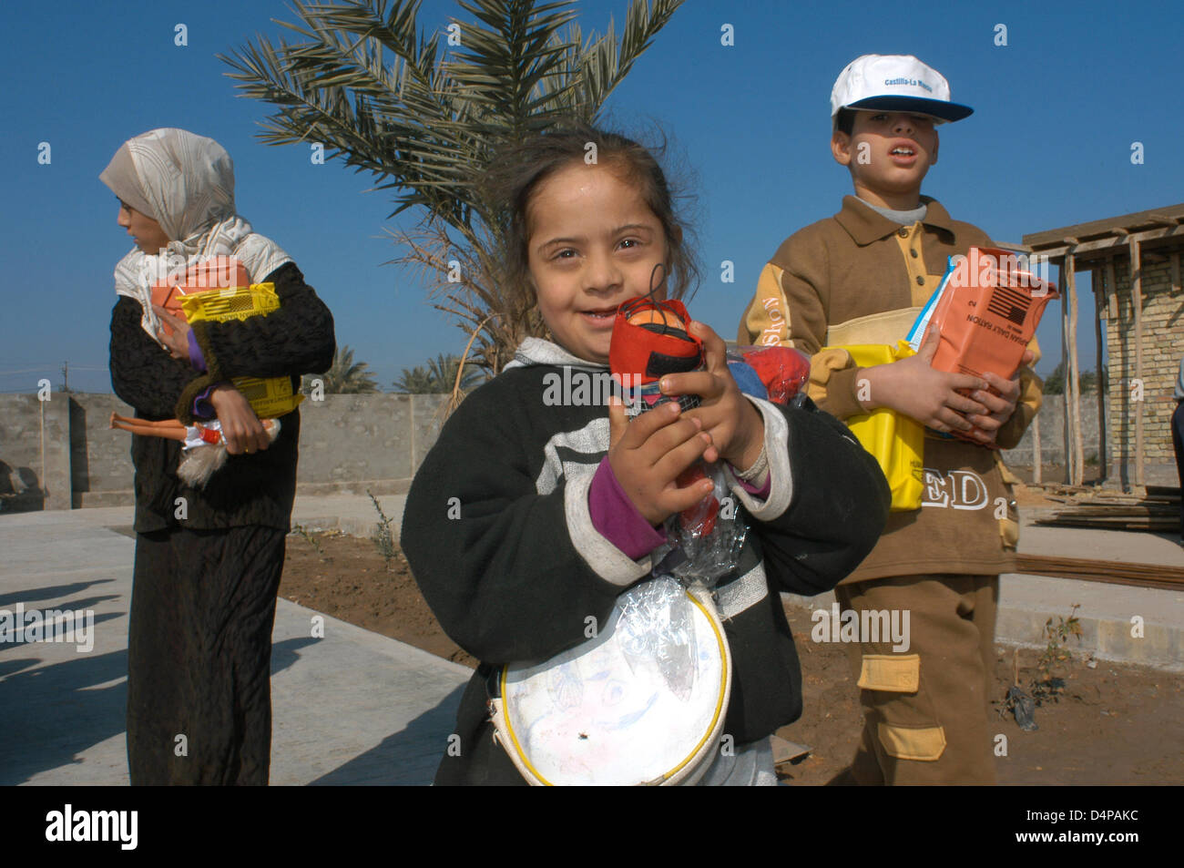 They get several boxes of humanitarian aid. While mothers are distributed warm clothes, children play around. Any clothing is welcome, although bearing the emblem of the people who murdered their family and friends. Stock Photo