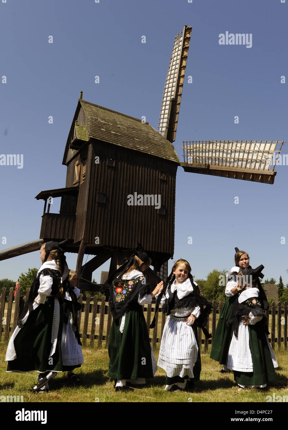 A traditional folklore and dancing group performs in front of a  ?Bockwind?-type mill at the International Mill Museum in Gifhorn, Germany, 01 June 2009. Alltogether 15 full-scale mills and 50 mock ups attracted thousands of spectators. According to operators the museum is the world?s largest of its kind. Photo: Holger Hollemann Stock Photo