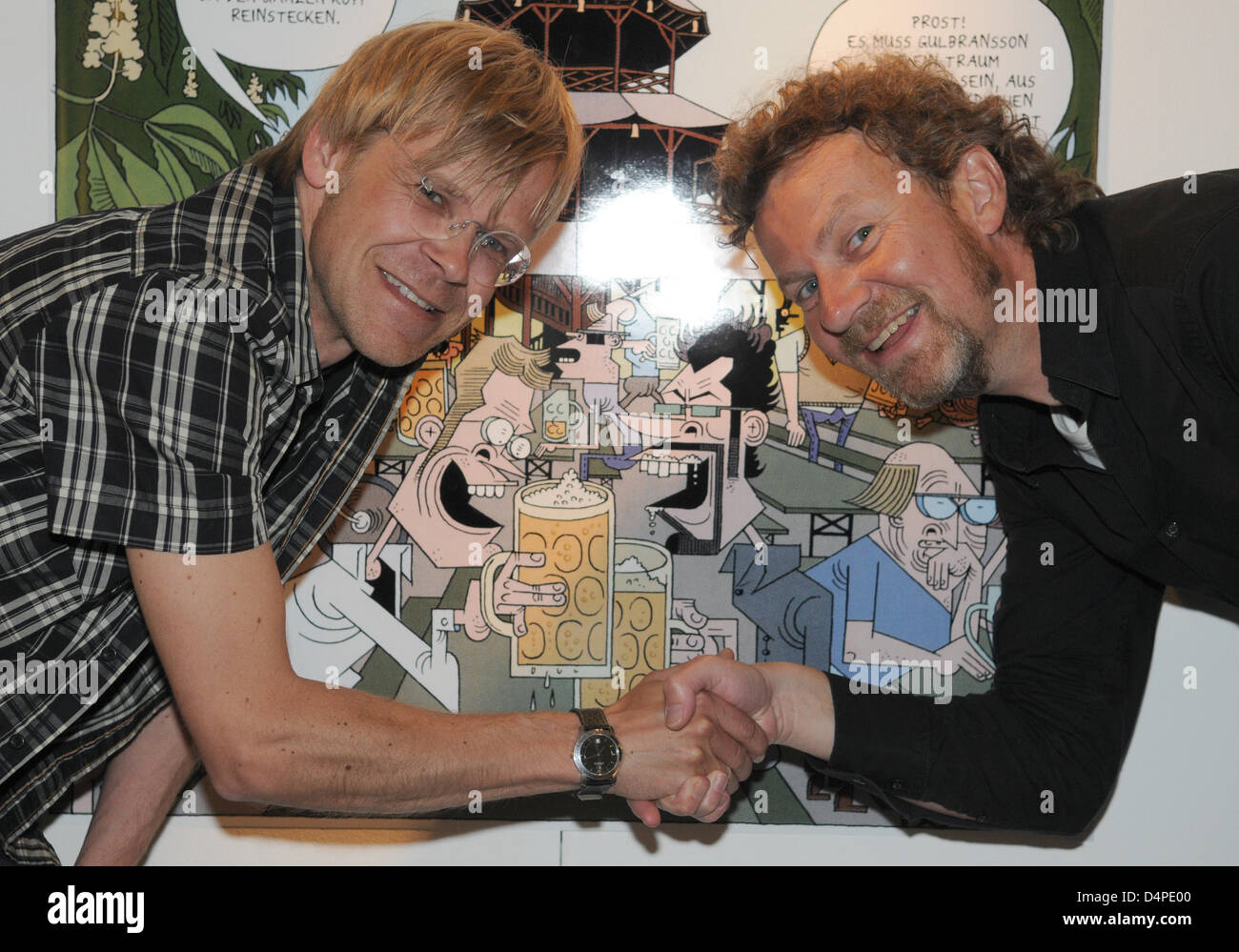 Norwegian artists Lars Fiske (L) and Steffen Kverneland pose in front of  one of their works at a vernissage of the Comic Festival in the town hall  in Munich, Germany, 10 June