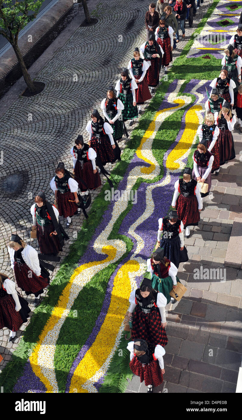 Women in traditional clothes walk along a carpet of flowers during the Corpus Christi procession in Huefingen, Germany, 11 June 2009. Volonteers had collected several million blooms for the carpet and worked on it since 10 June. Photo: PATRICK SEEGER Stock Photo