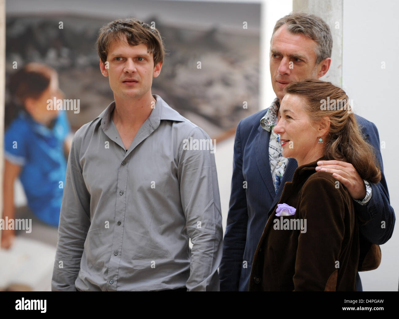 (L-R) German artists Tilo Baumgaertel, Neo Rauch and Rosa Loy smile for the camera during the 3rd work exhibition on residents of Leipzig cotton-spinning mill on the occasion of its 125th anniversary in Leipzig, Germany, 20 June 2009. Leipzig has evolved to one of the world?s most important art production locations especially by the so-called New Leipzig School and its about 100 ar Stock Photo