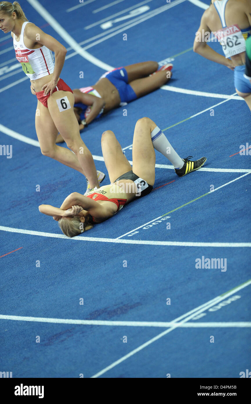 German Jennifer Oeser (C) is exhausted after the final 800m competition of the heptathlon at the 12th IAAF World Championships in Athletics in Berlin, Germany, 16 August 2009. Oeser won the silver medal. Photo: CHRISTOPHE KARABA Stock Photo