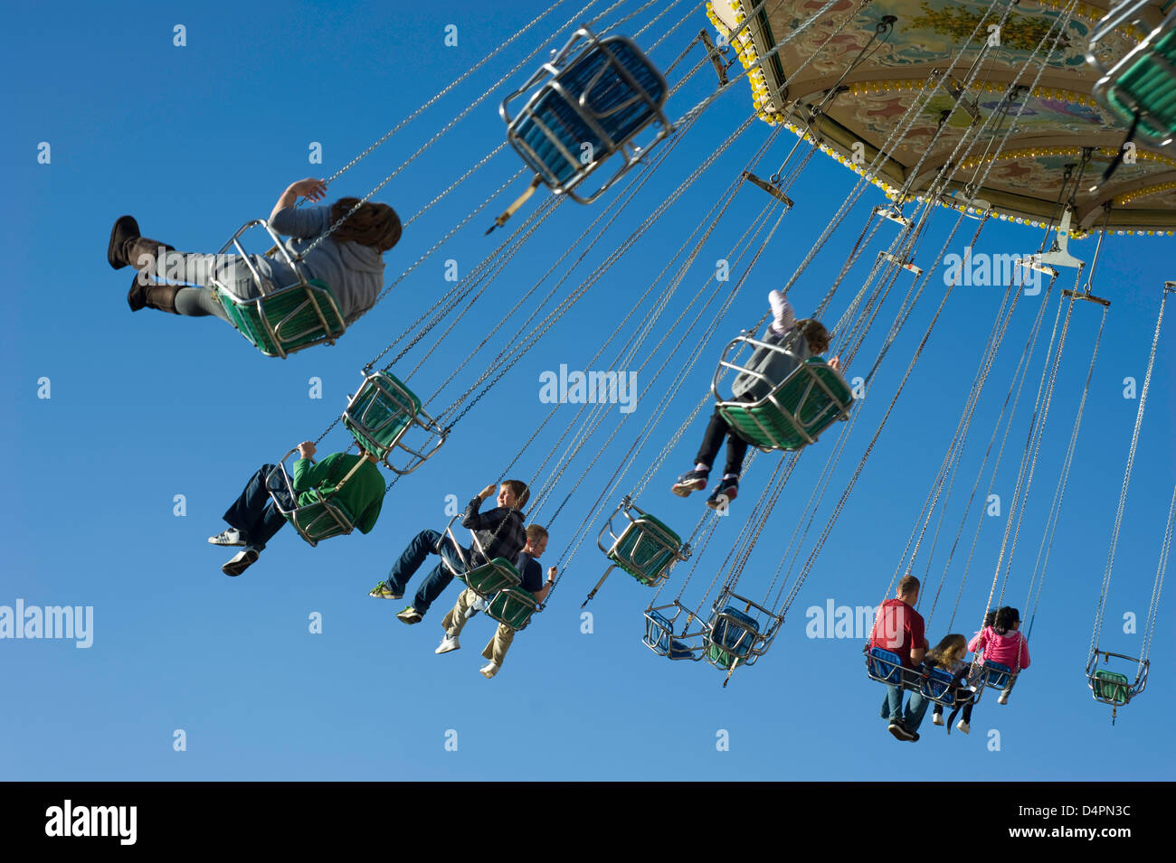 A mixed group of people at hight in on a fairground chair ride with ...