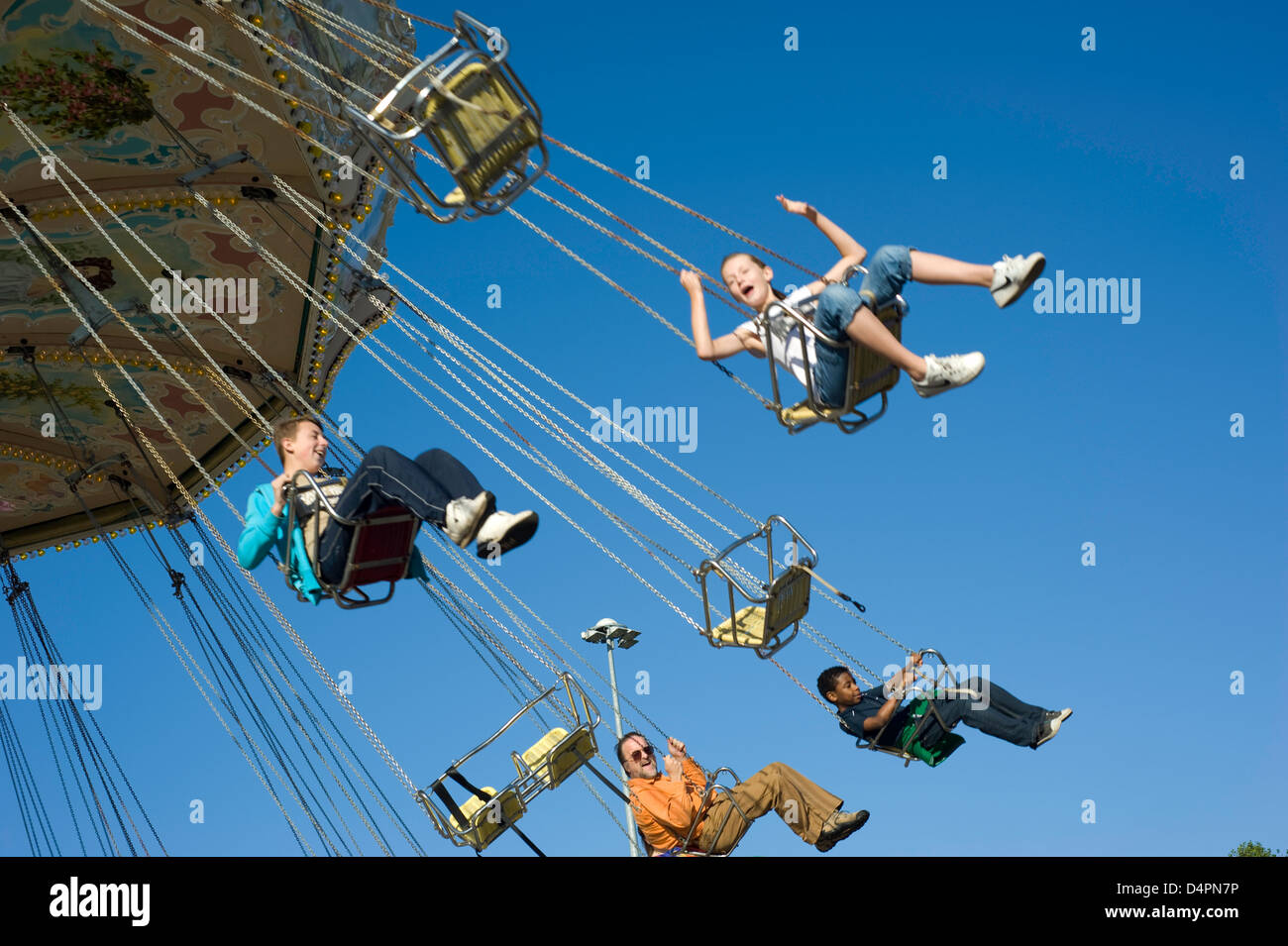 A mixed group of people at hight in on a fairground chair ride with ...