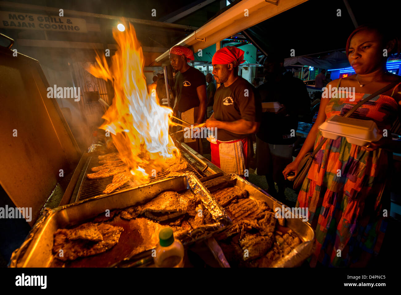Cooks frying up fish on a BBQ at Oistins fish fry night, Oistins, parish of Christ Church