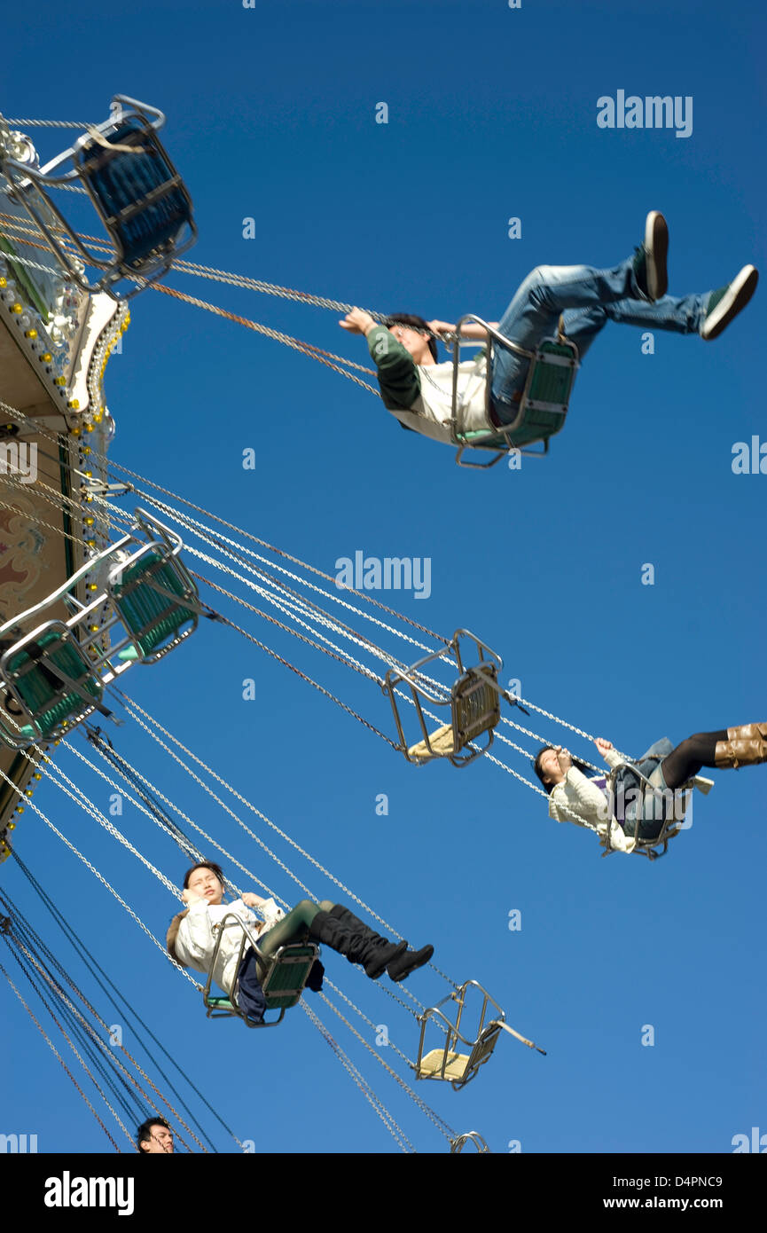 A mixed group of people at hight in on a fairground chair ride with ...