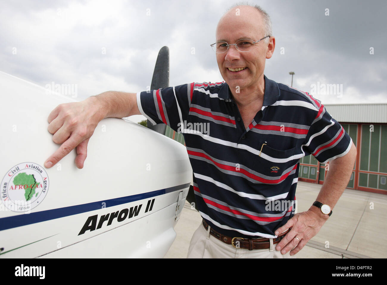 German Jochen Behtke poses in front of his single engined Piper PA 28 aircraft at the airport in Hamburg, Germany, 21 August 2009. One day later Behtke took off for a solo flight across the African continent to South Africa. On 02 September 2009 after 55 flight hours he called German press agency DPA and reported a safe landing in Capetown at 14:30 local time. 48 year-old Behtke li Stock Photo