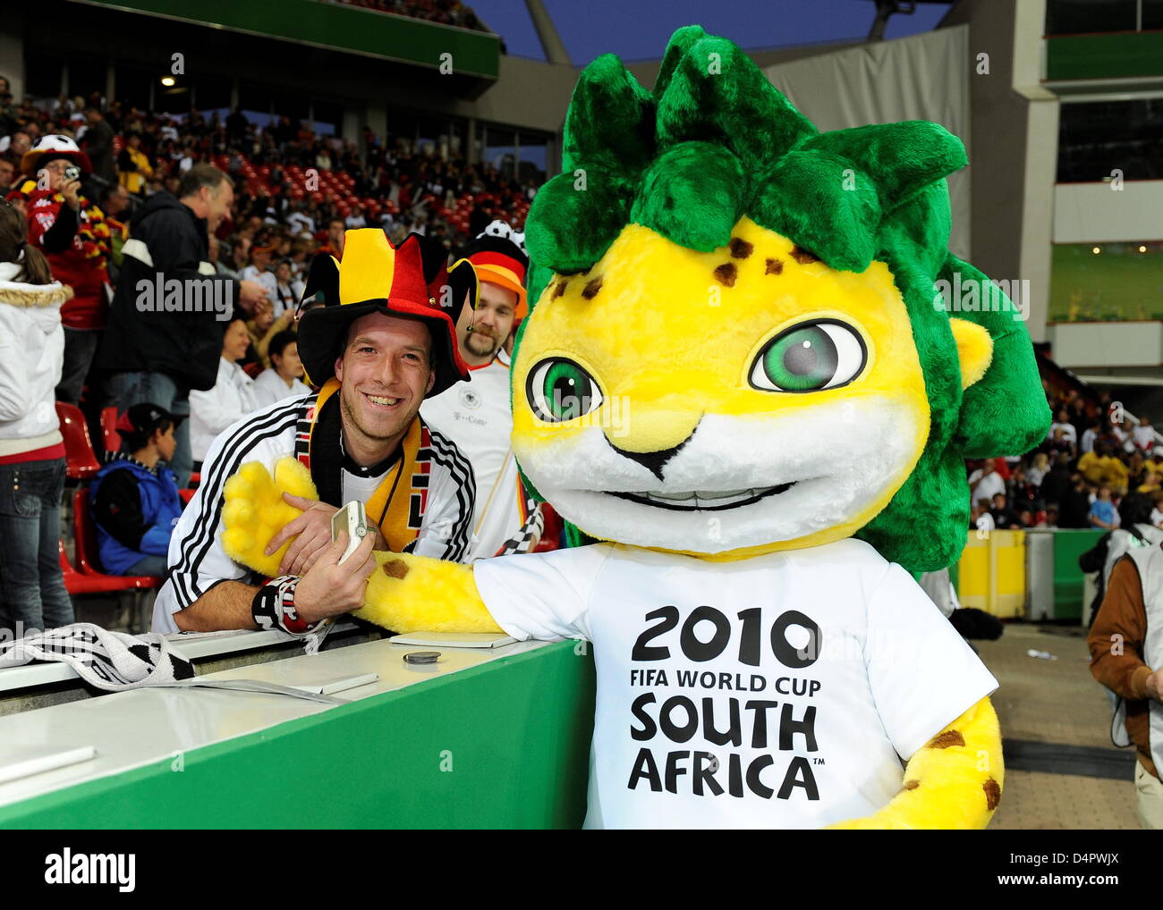 Zakumi (R), mascor of the 2010 FIFA World Cup, smiles with a fan ahead of the friendly match Germany v South Africa at BayArena stadium of Leverkusen, Germany, 05 September 2009. Germany won the match 2-0. Photo: Achim Scheidemann Stock Photo