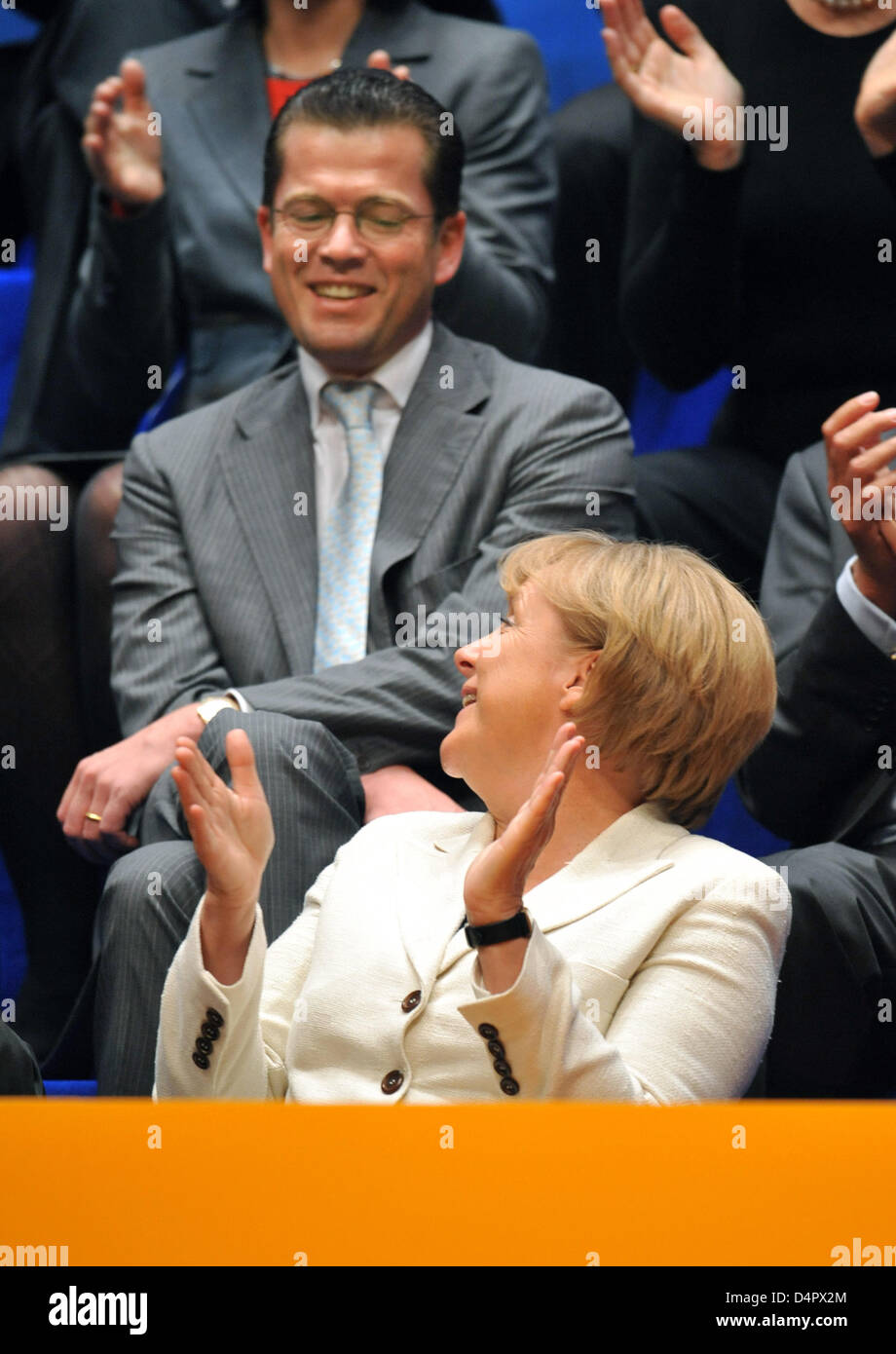 German Chancellor Angela Merkel (front) smiles to German Minister of Economy Karl-Theodor zu Guttenberg (back) as her Christian Democrats (CDU) party kicks off its election campaign in Duesseldorf, Germany, 06 September 2009. CDU enters the final phase of its election campaign for the federal elections held on 27 September. Photo: BERND THISSEN Stock Photo