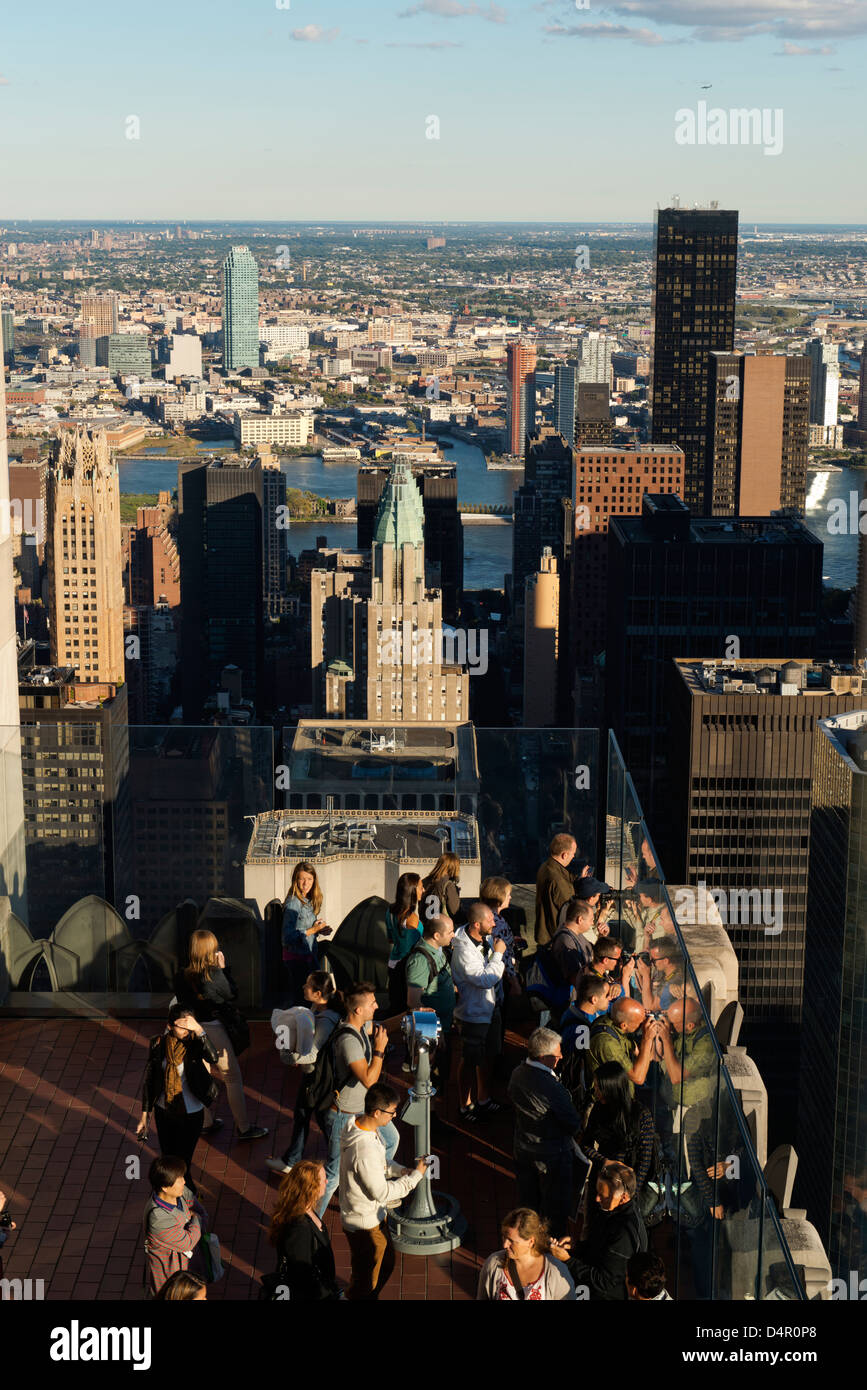 Tourists on the viewing deck of the Rockefeller Center and view of New York City on a sunny day. Stock Photo