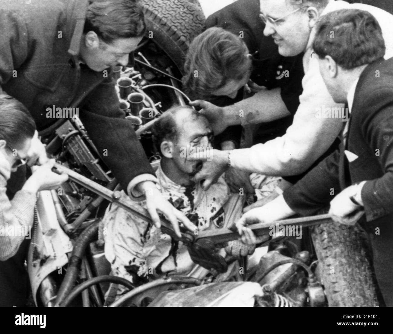 (dpa file) A file picture dated 23 April 1962 captures British motor racing legend Sir Stirling Moss (C) being freed out his Lotus Climax after crashing with 160 kph in Goodwood, UK. Sir Stirling Moss will celebrate his 80th birthday on 16 September 2009. Photo: Harry Melchert Stock Photo