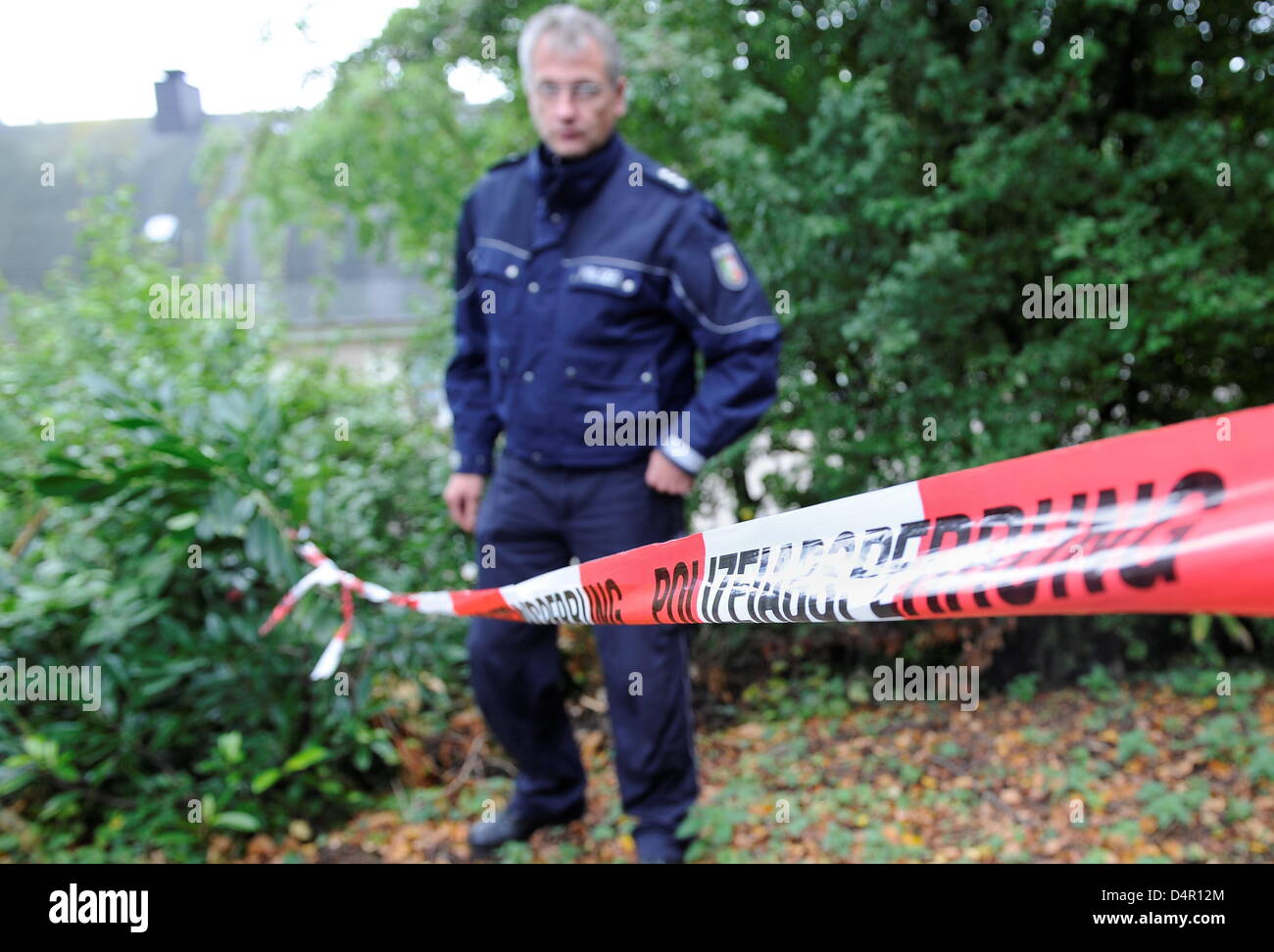 A police officer secures the area where a nine-year-old girl was found in Vlebert, Germany, 15 September 2009. Police found a perilously injured nin-year-old girl in a sewer chamber. Relatives had posted the child as missing after she did not return home on 14 September. Police investigates on the base of strong suspicion for a capital offence. The girl was hospitalised and is not  Stock Photo