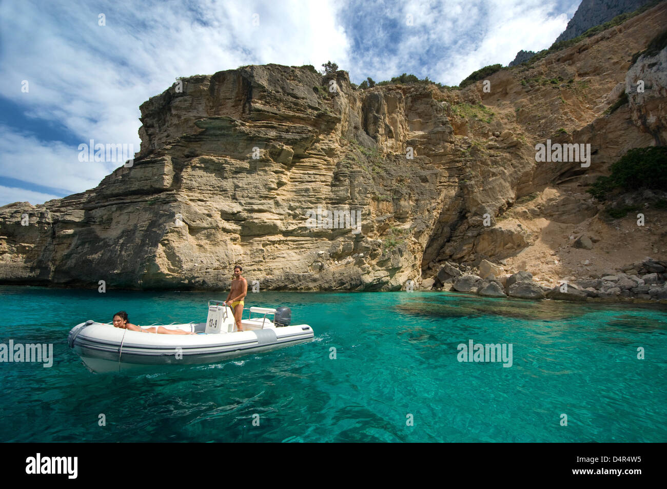 Tourists on zodiac boat enjoy the sea and coast of Orosei gulf, near Cala Mariolu beach, Baunei