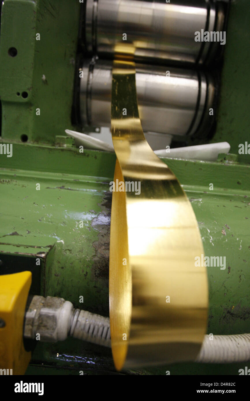 (dpa file) A file picture dated 02 February 2009 depicts a ribbon of gold leaf emerging from a mill that transformed a gold bullion into the ribbon at Eytzinger gold-beatery in Schwabach, Germany. Only a handful of people still master the craft of maunfacturing the very thin material, few factories in Europe produce gold leaf with machines. At the start of the 20th century, Schwaba Stock Photo