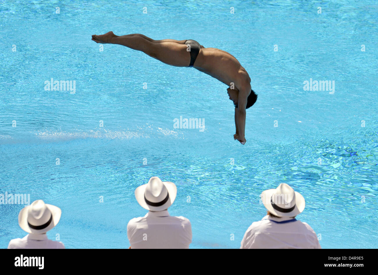 Judges watch as Chinese He Chong performs during 3m diving competition