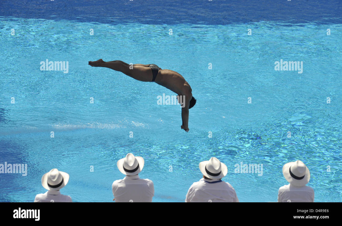 Judges watch as Chinese He Chong performs during the 3m diving