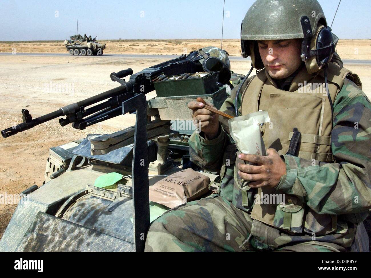Sergeant John Stanley of the 3rd reconnaissance batallion of the US Marine infantry is eating the half of his daily ration, on 29 March 2003, near Ad Dianiyah in southern Iraq. Stock Photo