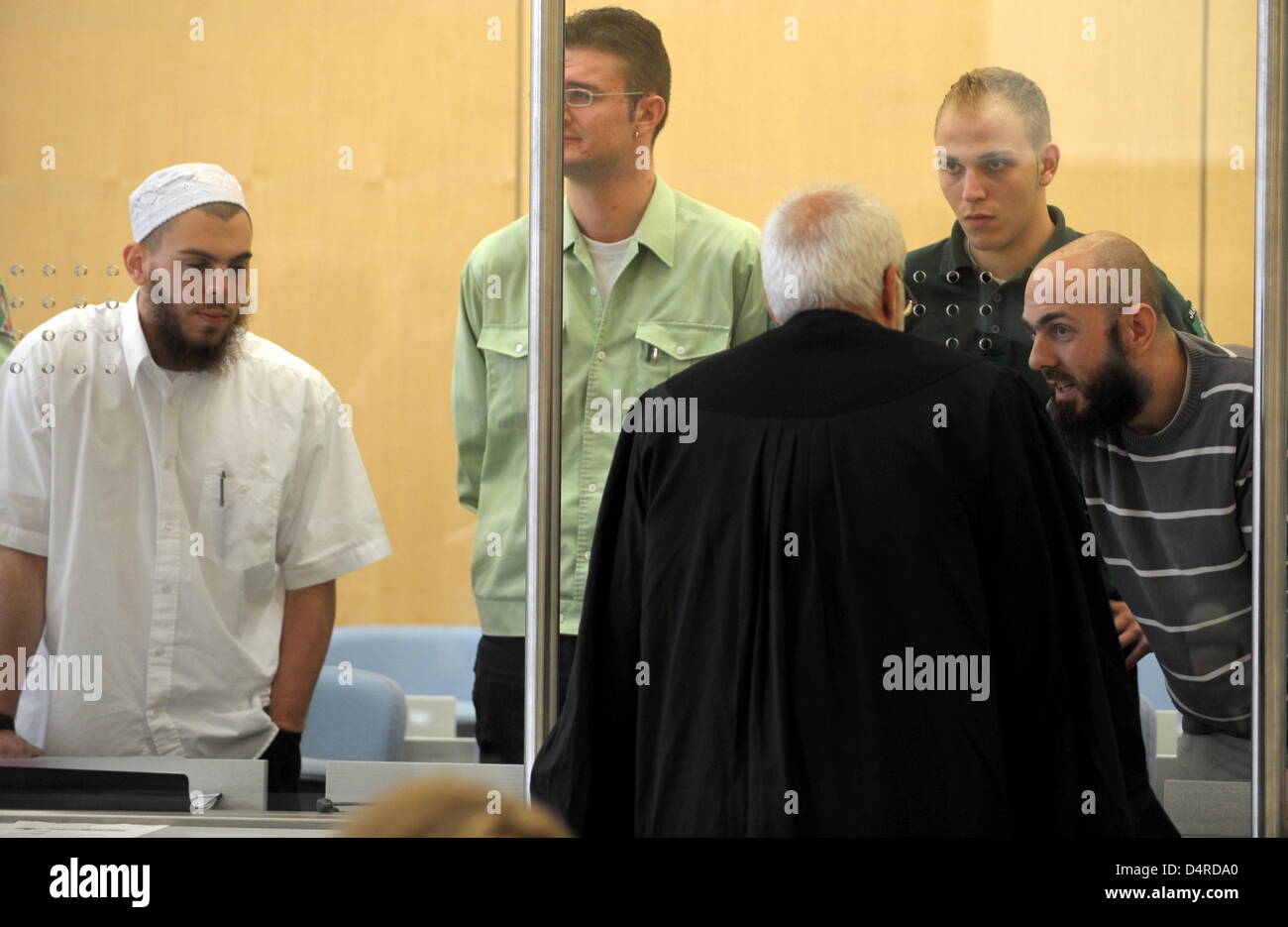 Defendant Adem Yilmaz talks to his lawyer Karl Engel in the hearing room at the Higher Regional Court in Duesseldorf, Germany, 10 August 2009. Defendant Daniel Schneider is pictured to the left. The defendants in the terror trial against the so-called ?Sauerland group? kept their word and started making broad confessions. The four men already had more than 1000 pages of confessions Stock Photo