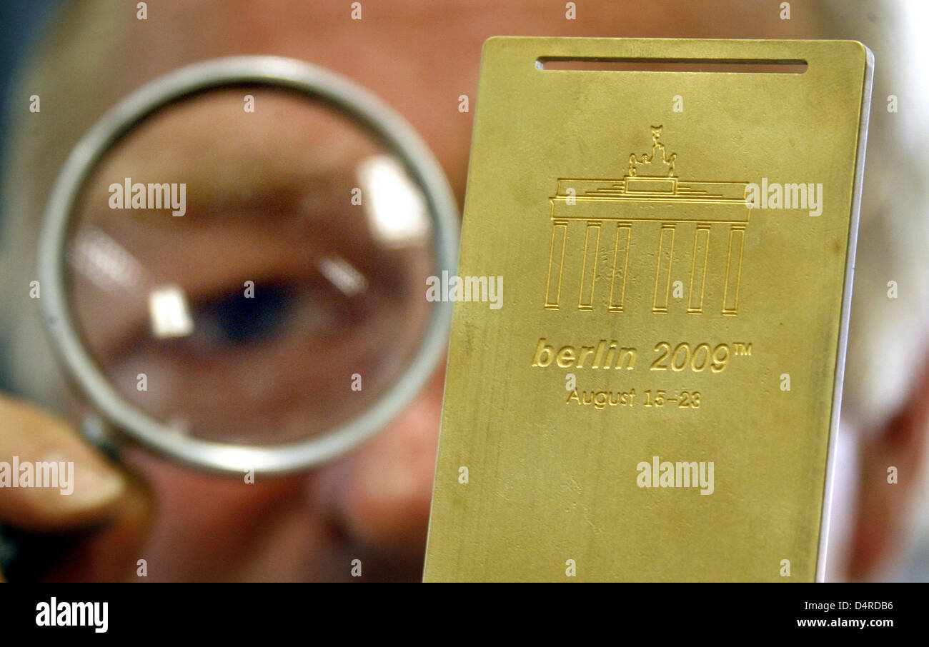 A Weidling employee checks the motive for a medal after an acid bath in Berlin, Germnay, 10 August 2009. The IAAF World Athletics Championships begin in Berlin on 15 August 2009. Weidling produces the medals for the championships. Photo: WOLFGANG KUMM Stock Photo