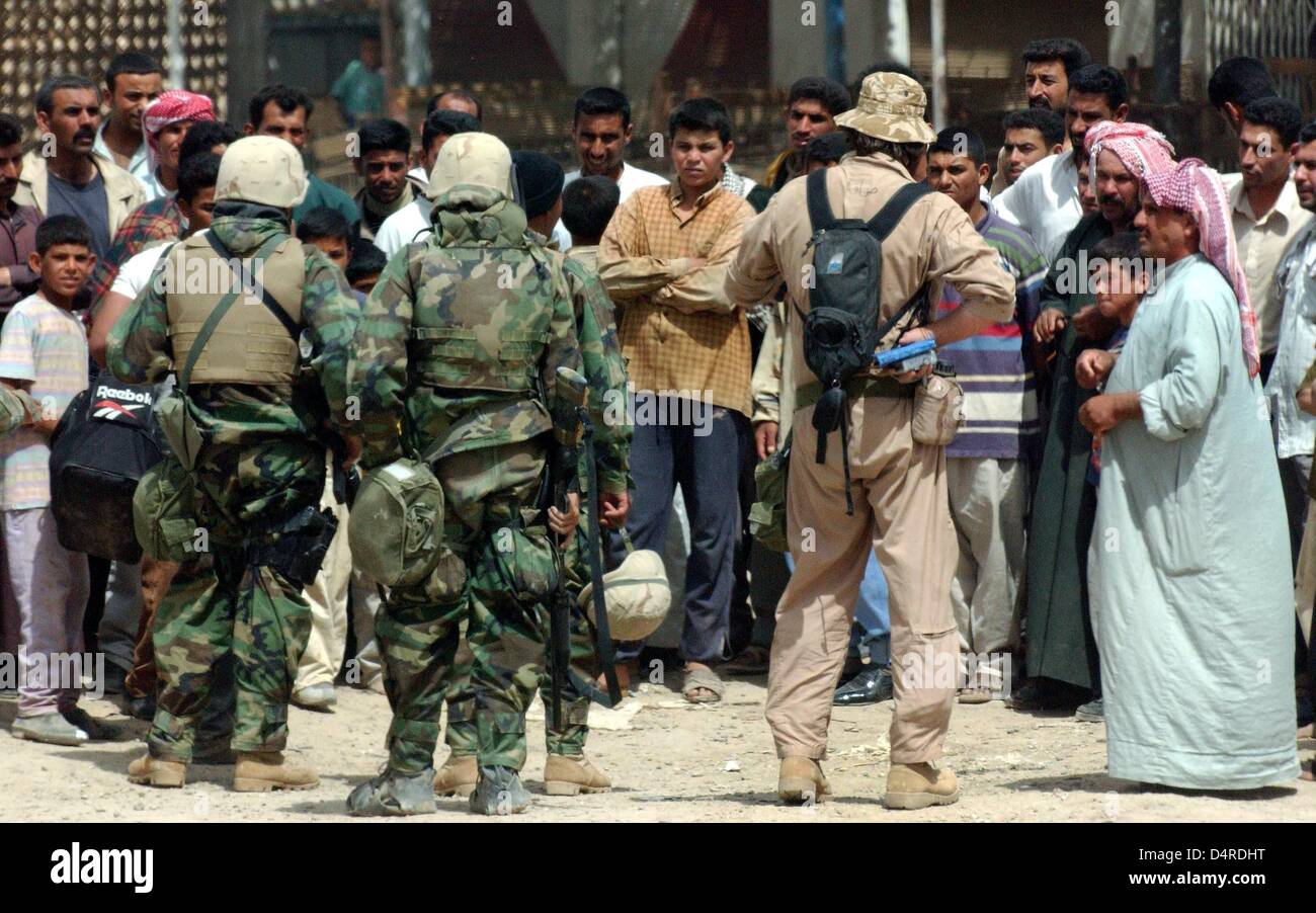 Iraqi civilians meet US marines on 4 April 2003 near Al Aziziyan, 40 kilometers south ob Baghdad. Stock Photo