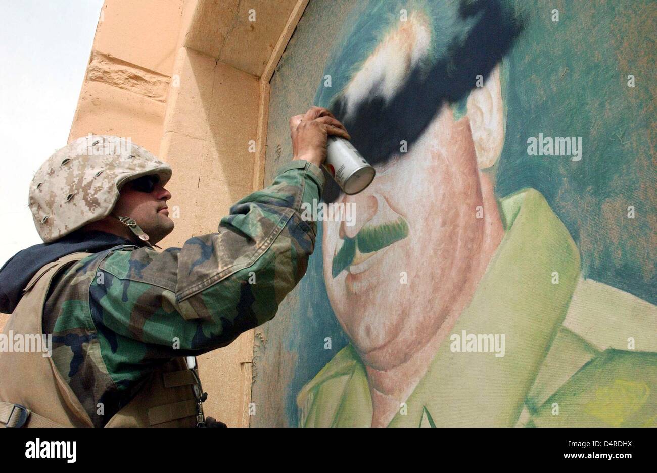 Sergeant John Stanley of the US marines of the 3rd Light Armored Reconnaissance Batallion sprays a Saddam picture on 6 April 2003 near Thamir, a suburb of Baghdad. Stock Photo