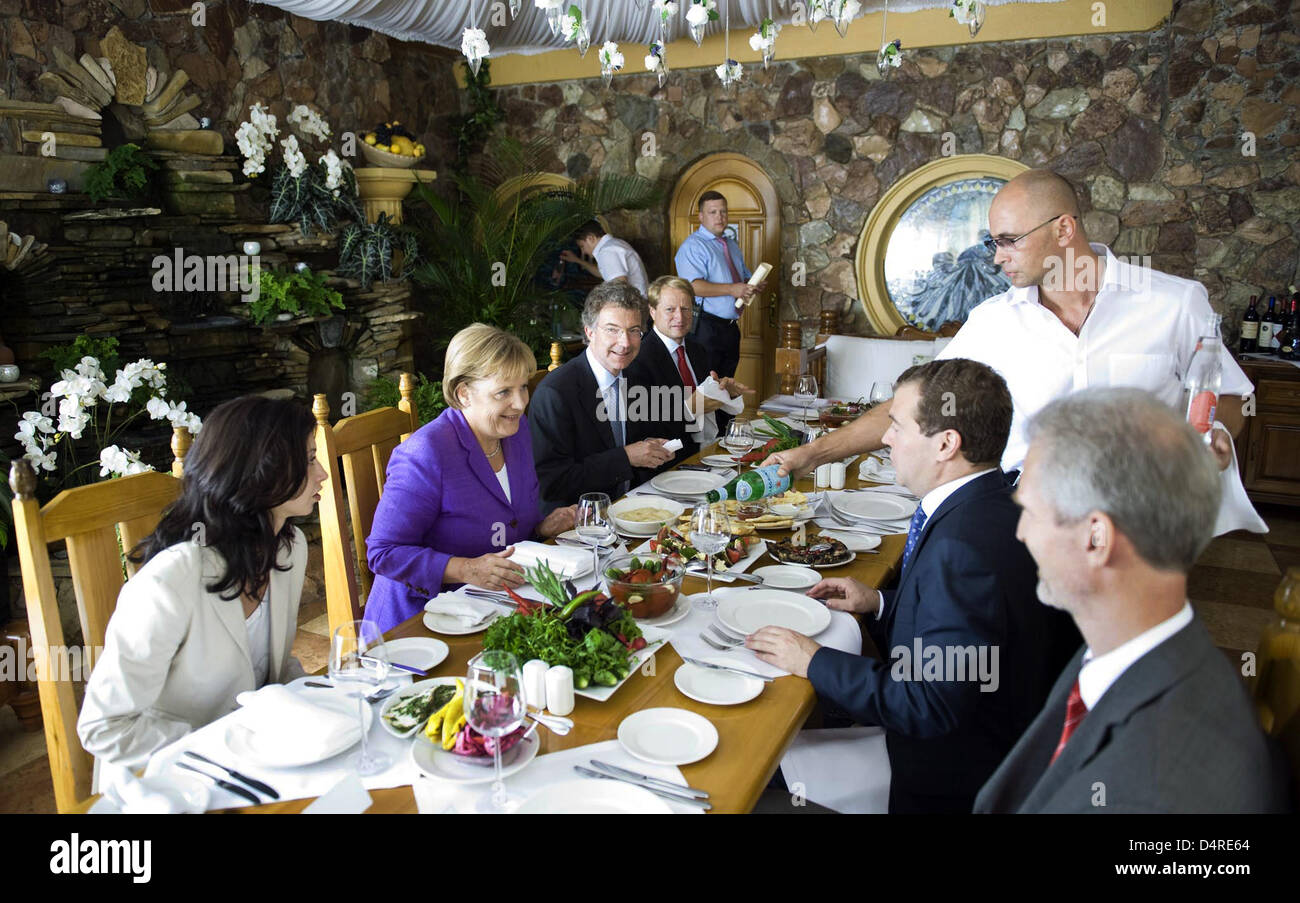 Russian President Dmitry Medvedev (R) and German Chancellor Angela Merkel (L) are having their lunch in a restaurant in the Black Sea resort Sochi, Russia 14 August 2009. Energy cooperation and investment projects are set to dominate talks between Russian President Dmitry Medvedev and German Chancellor Angela Merkel. Photo: Guido Bergmann /Bundesregierung / pool Stock Photo