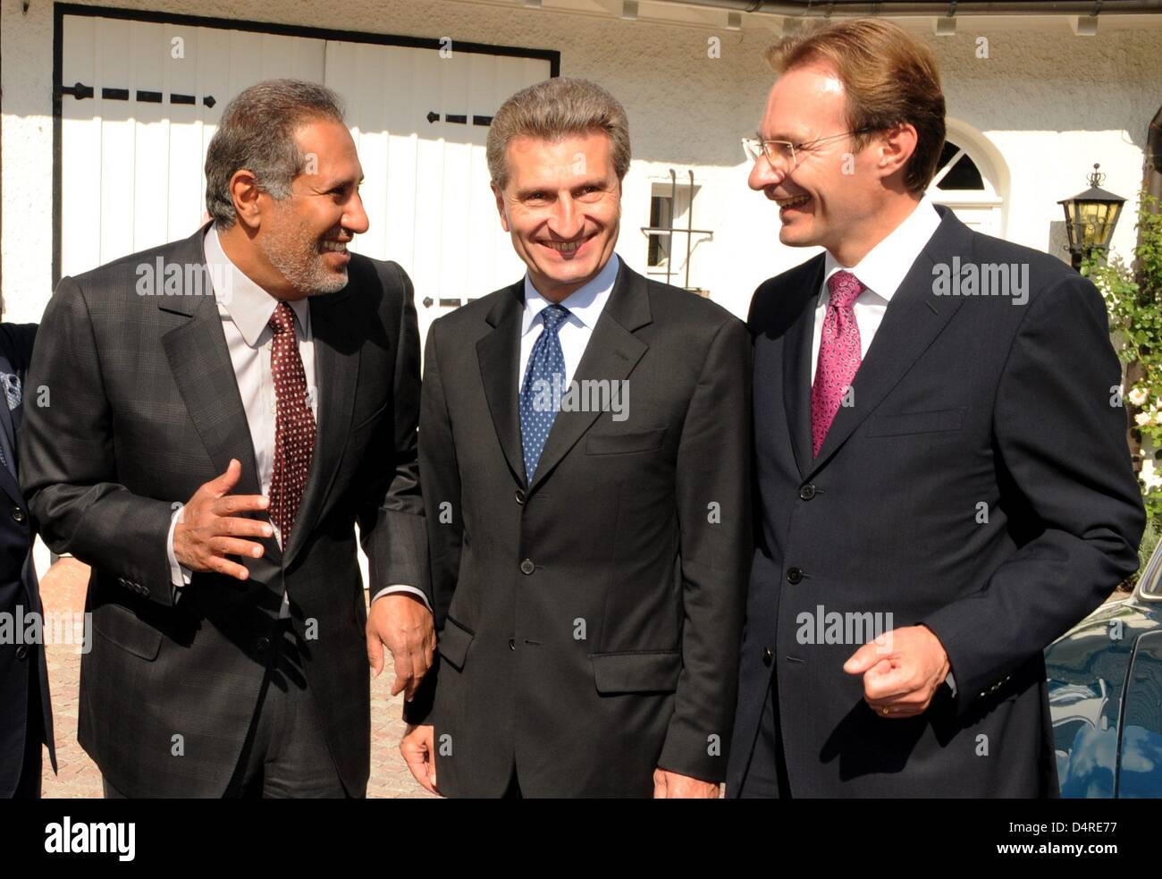 sheik hamad bin jassim bin jaber al thani of qatar l talks to michael macht r ceo of porsche while baden wuerttemberg s prime minister guenther oettinger smiles between them in front of the