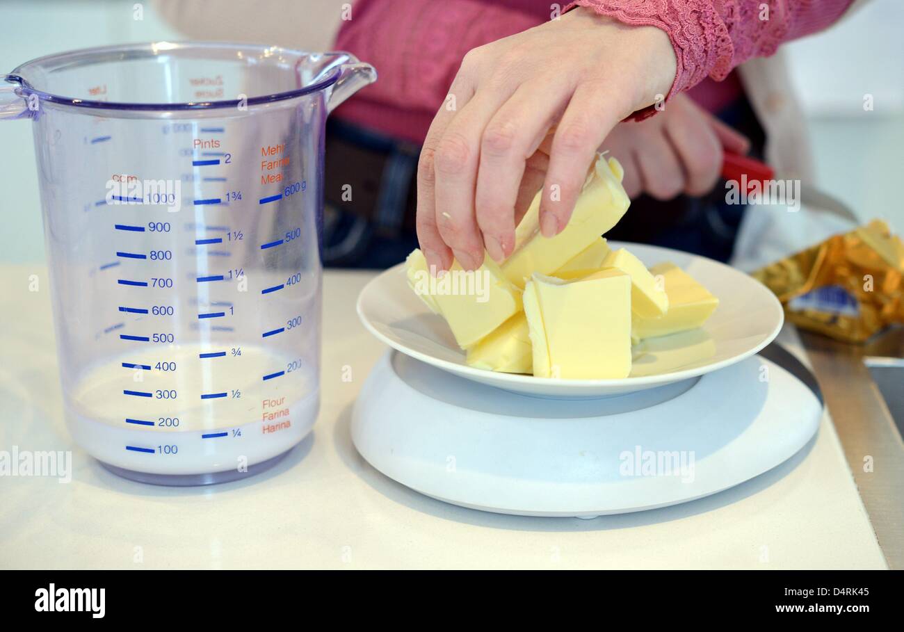 A cake is getting prepared in a kitchen. Photo: Frank May Stock Photo