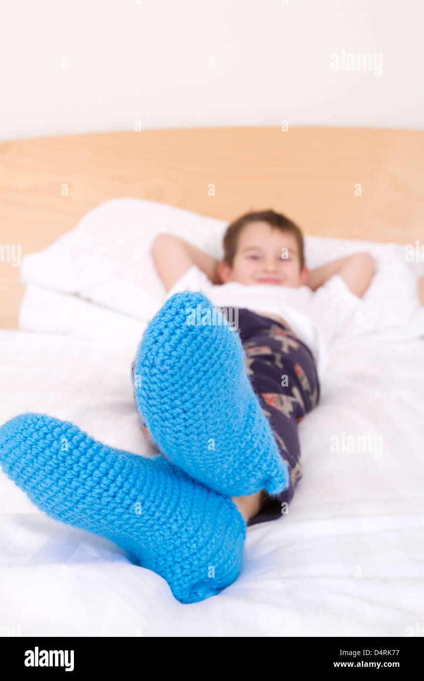 Seven years old kid cozy wearing his knitted winter socks proudly. Ready for winter Stock Photo