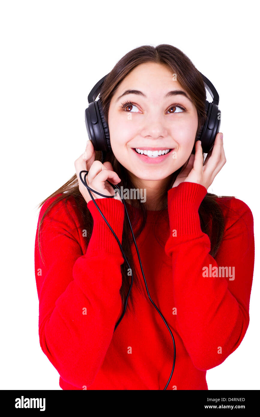 Teenager girl listening music in headphones, looking up to something. She is wearing catchy red clothing relaxed. Isolated. Stock Photo