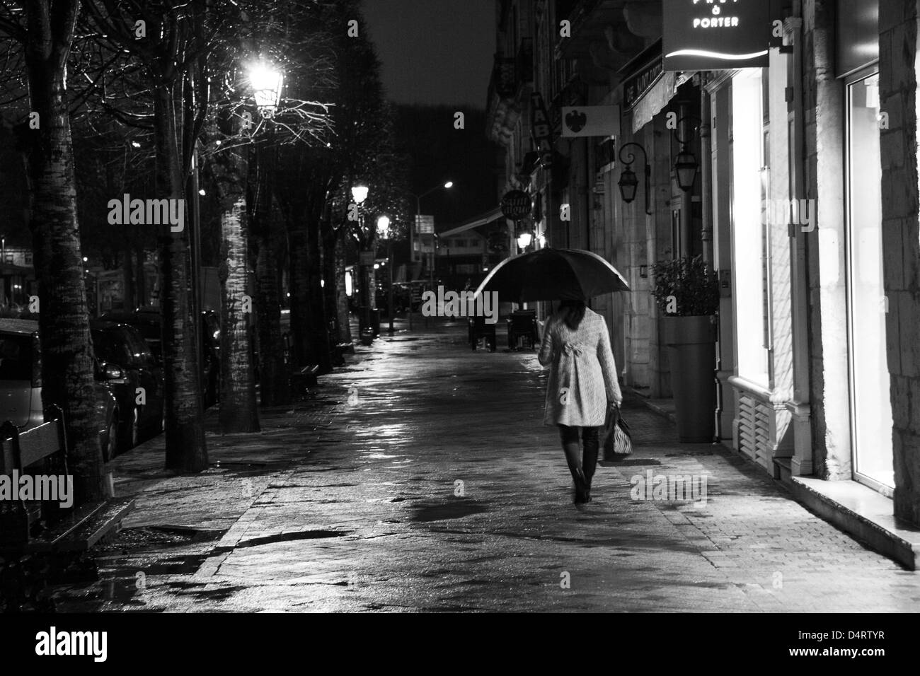 French woman walking in town at night Stock Photo