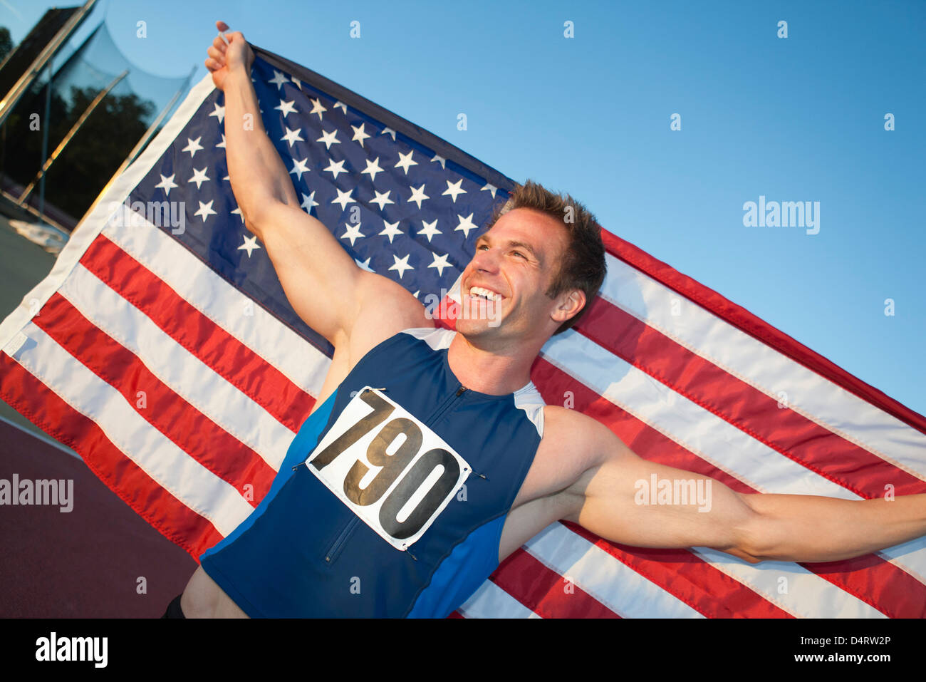 Male athlete holding up American flag Stock Photo