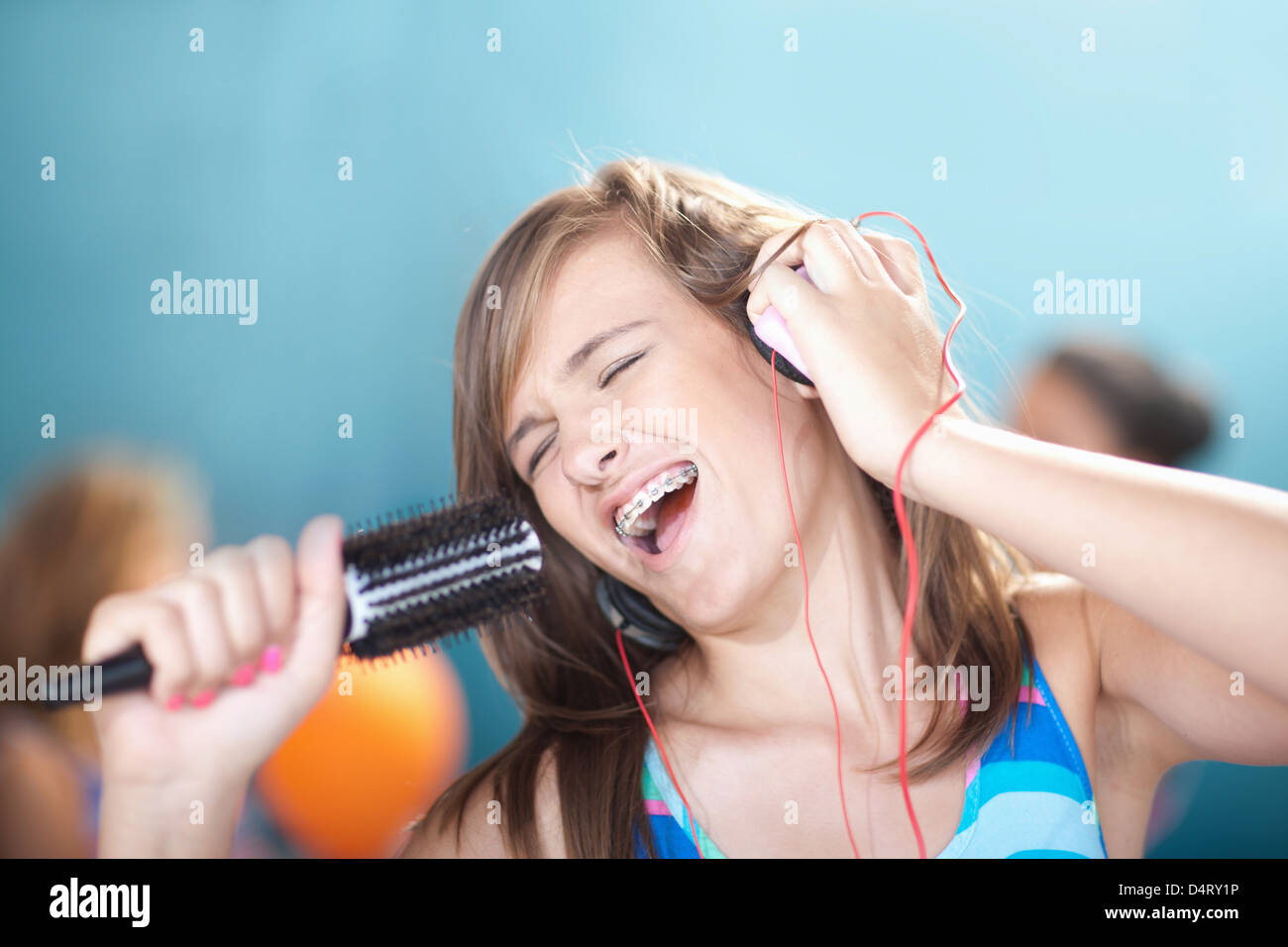 Teenage girl singing into hairbrush Stock Photo - Alamy