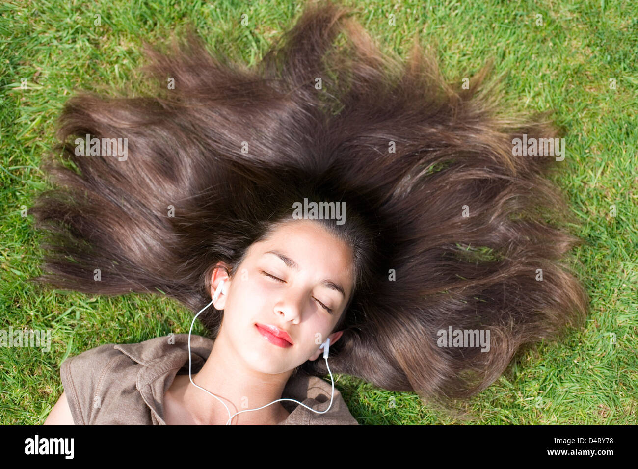 Teenage Girl Lying on Grass Listening to Music through Headphones Stock ...
