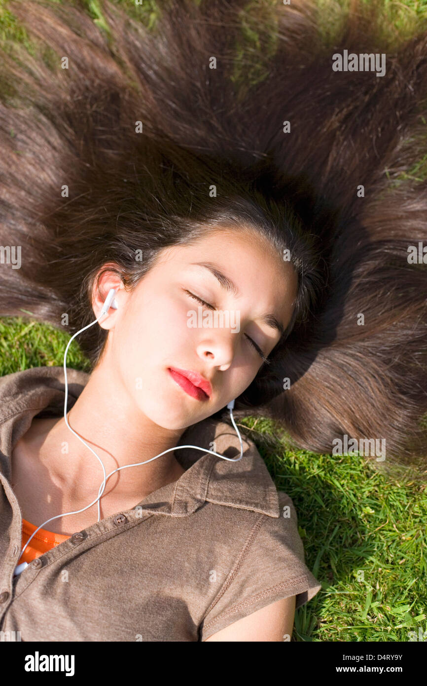 Teenage Girl Lying on Grass Listening to Music through Headphones Stock ...