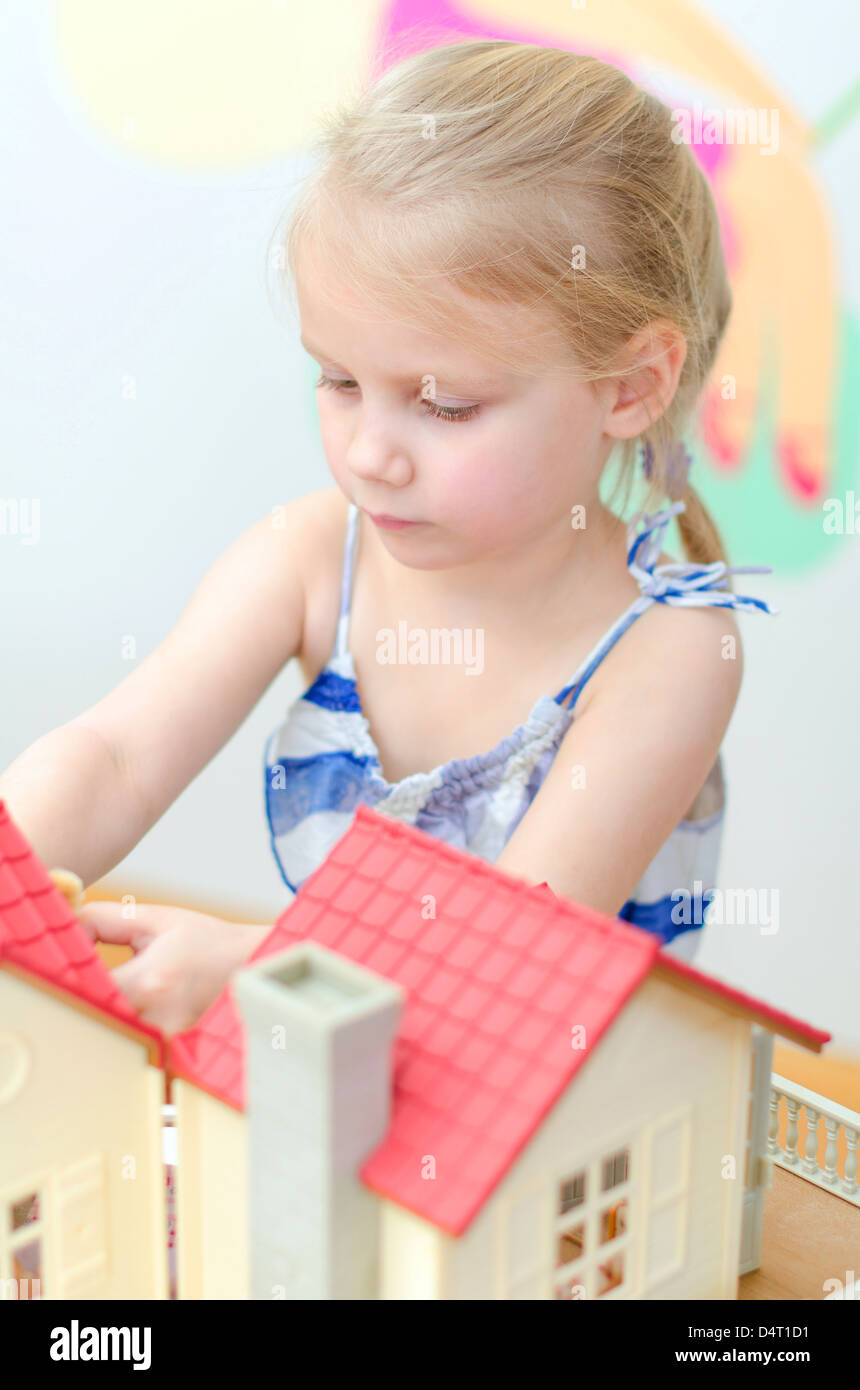 Little girl playing with dollhouse Stock Photo - Alamy