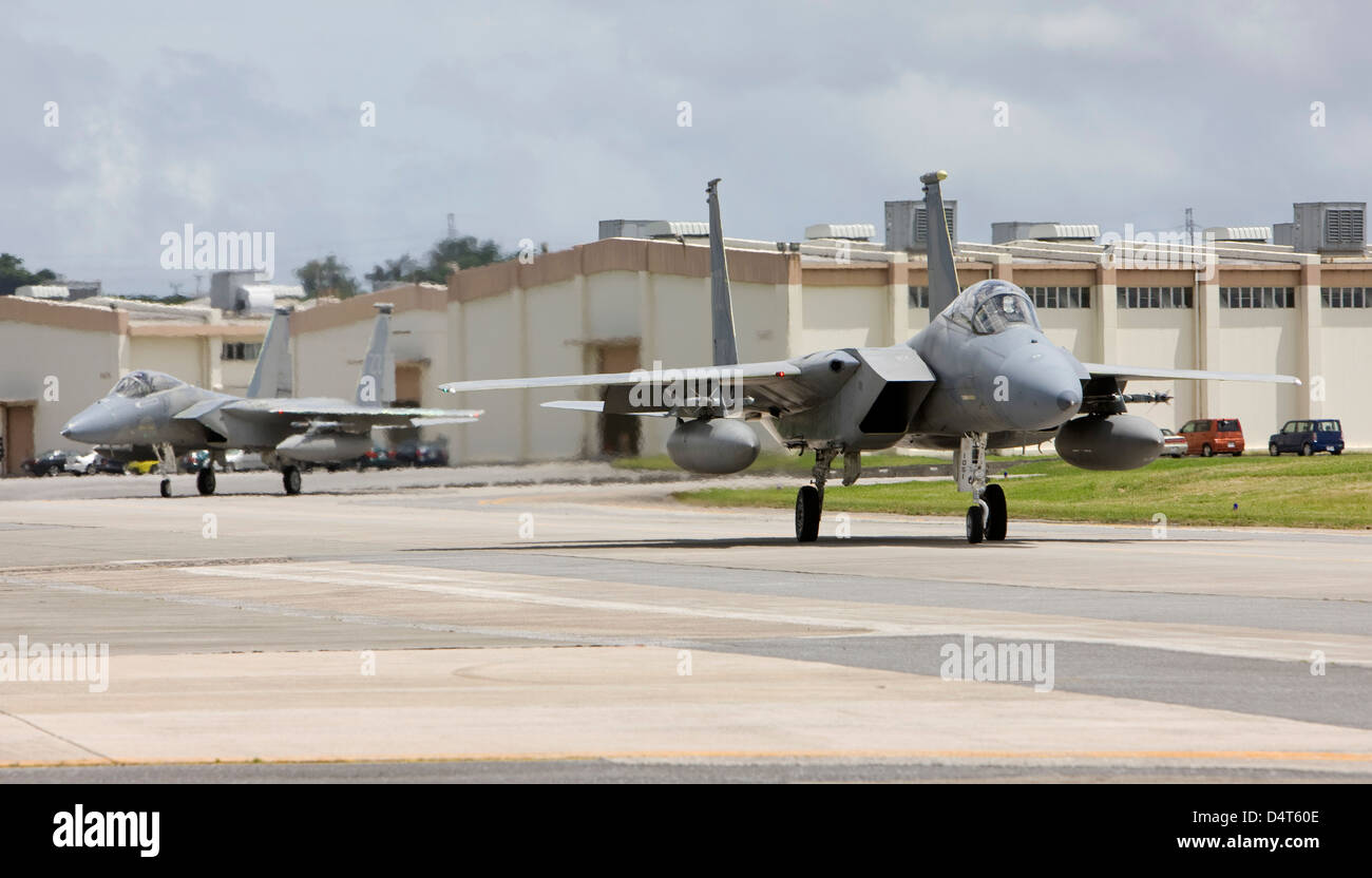 Two F-15's from the 18th Wing at Kadena Air Base, Okinawa taxi to the end of runway to complete thier pre-flight checks. Stock Photo