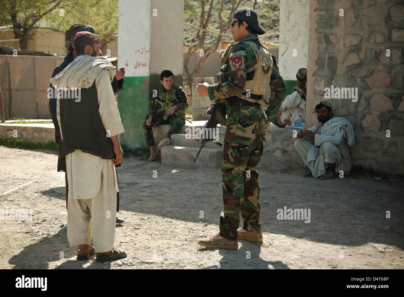 An Afghan National Army Special Forces speaks with Afghan Local Police candidates during a recruitment validation March 16, 2013 in Helmand province, Afghanistan. Stock Photo