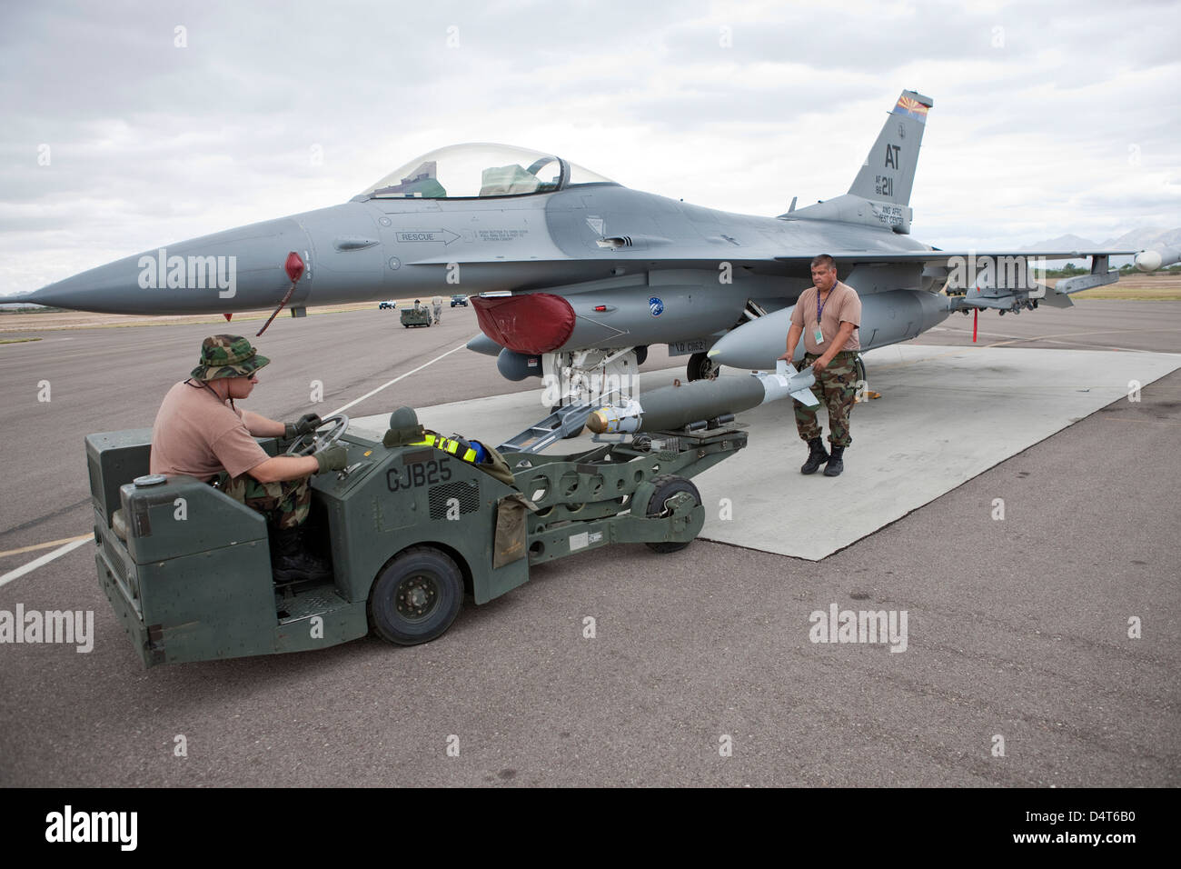 Weapons loaders prepare to load a GBU-38 JDAM on an F-16. Stock Photo